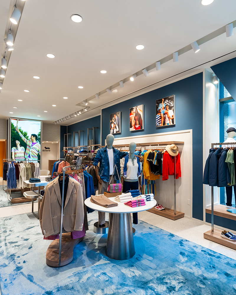 Innenansicht des Harmont & Blaine Stores mit farbenfroher Kleidung.