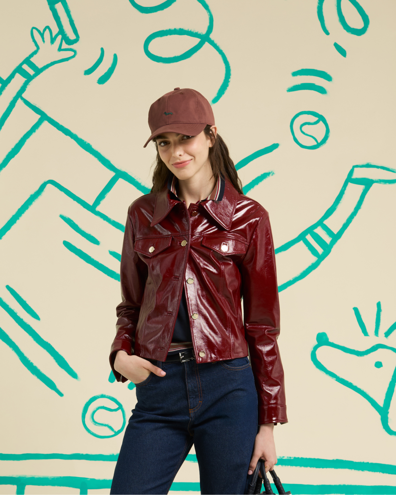 Donna con giacca in pelle nera, maglione a fantasia e marsupio beige