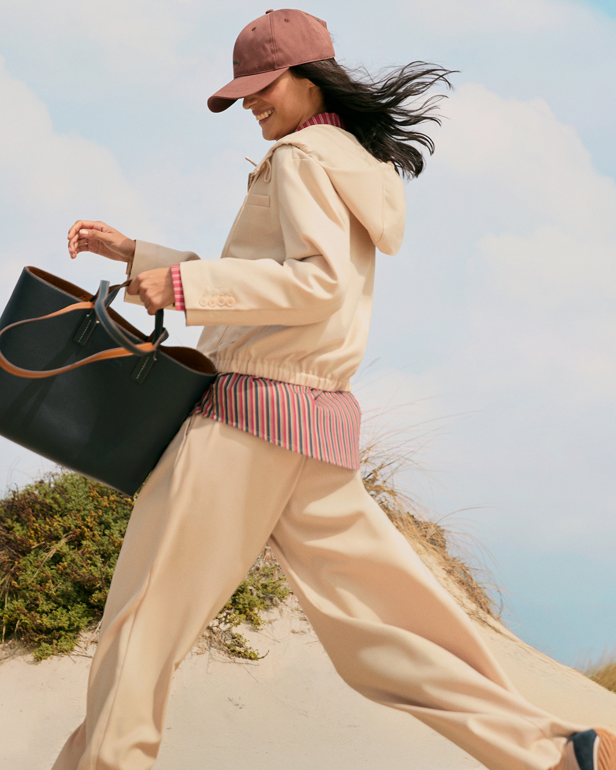 Donna con bomber giacca crema con bordini a righe e pantaloni blu navy