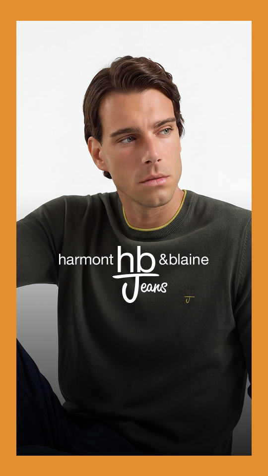 L'immagine rappresenta il banner promozionale per la promo HallowEEK HB Jeans. Mostra un modello maschile seduto su sfondo chiaro con maglia verde oliva e pantaloni scuri, incorniciato da un bordo arancione e sovrastato in posizione centrale dal logo bianco "Harmont & Blaine HB Jeans