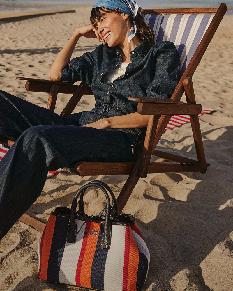 Donna con bomber giacca crema con bordini a righe e pantaloni blu navy