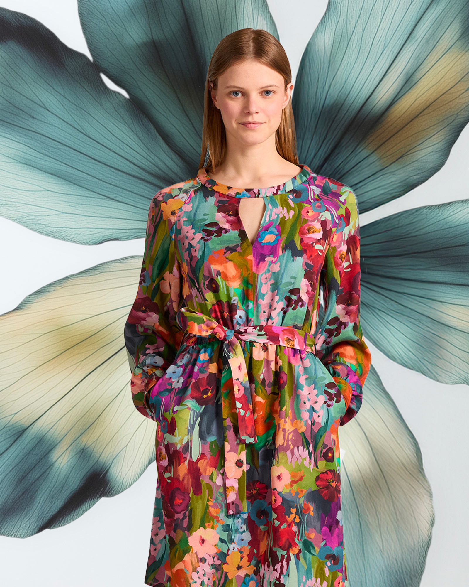 Woman wearing a colorful floral dress with matching belt.