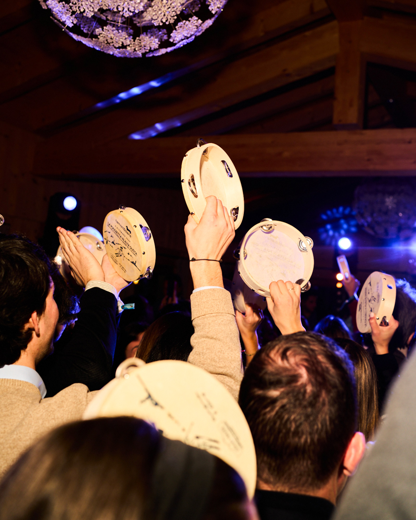 Pubblico che solleva tamburelli durante una performance live.