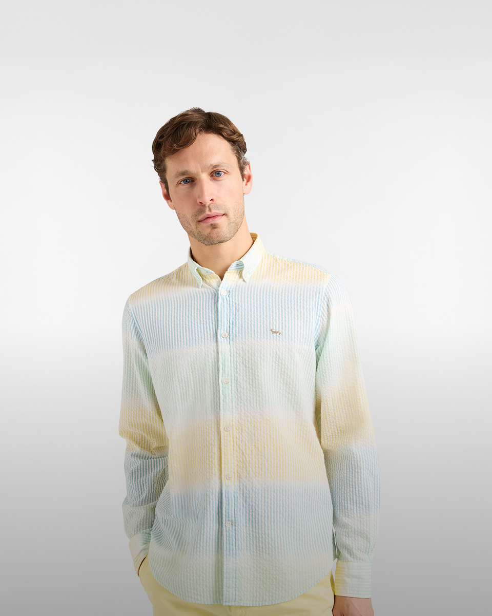 Donna con giacca a vento beige e camicia a righe con cappellino rosa