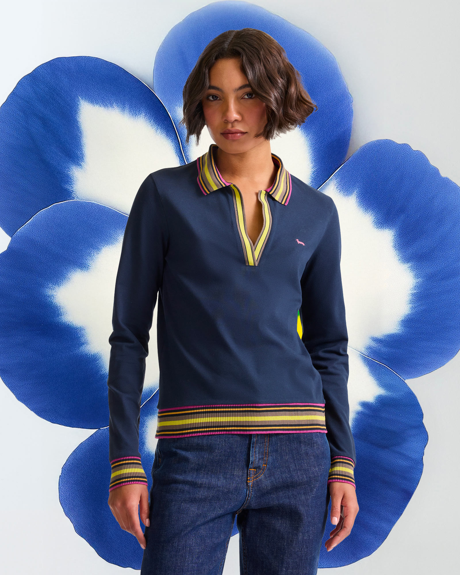 Light polo in foreground, stylized blue flower behind.