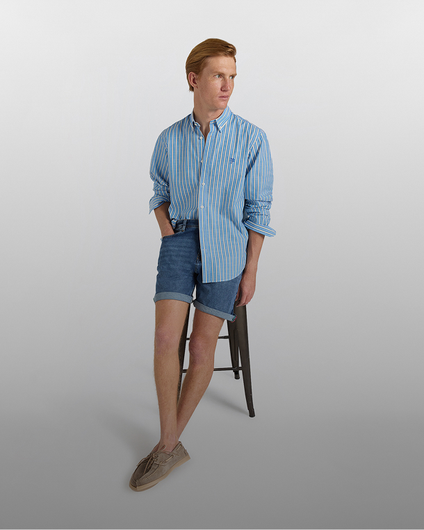 Coppia in spiaggia con polo a righe e cappellini da baseball