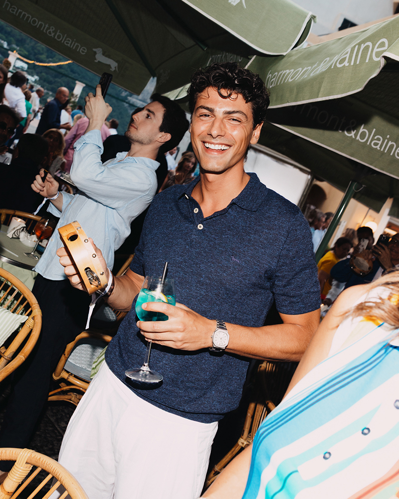 Uomo sorridente con cocktail all'evento Harmont & Blaine a Capri.