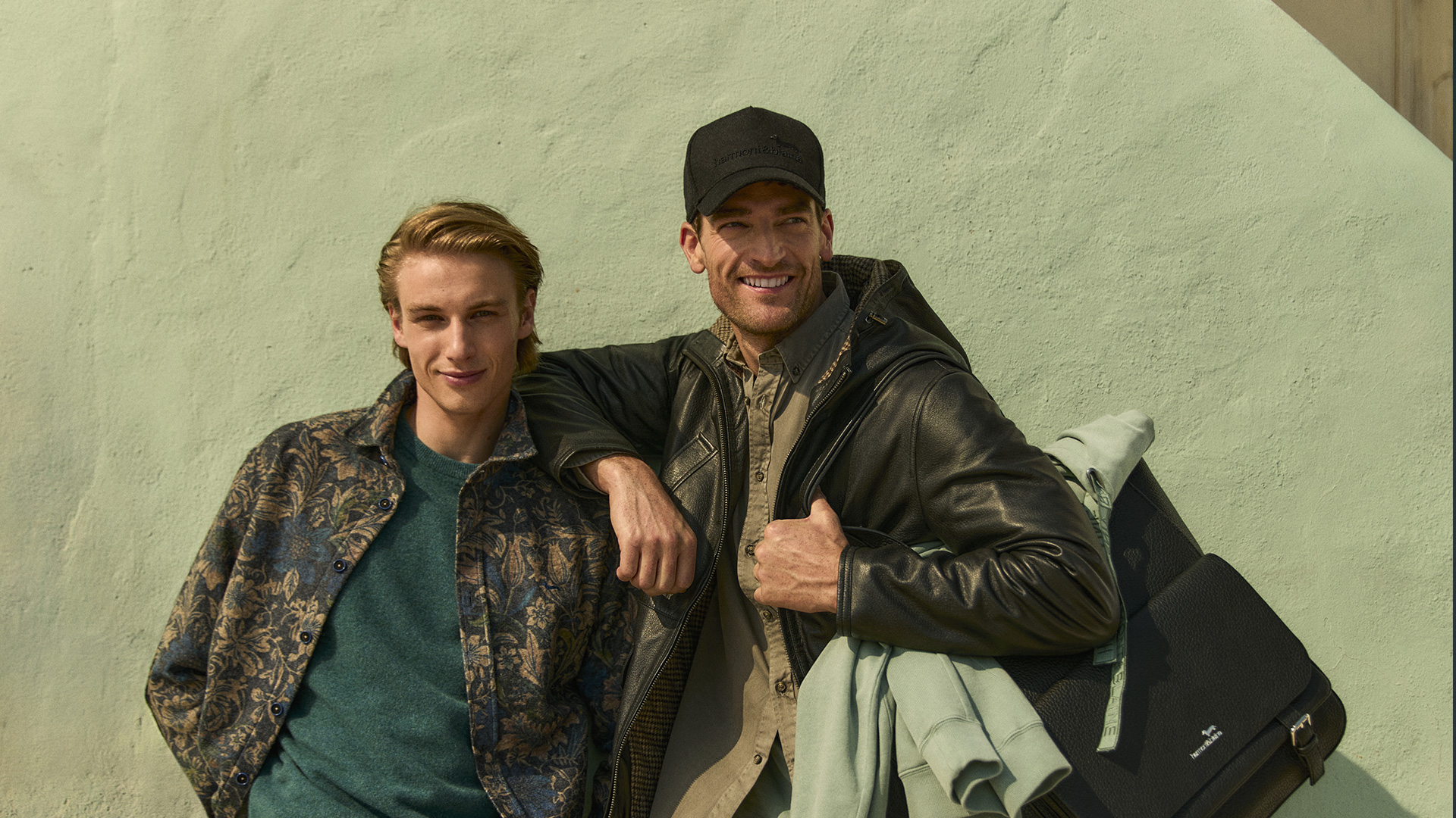 Two smiling men in stylish casual jackets.