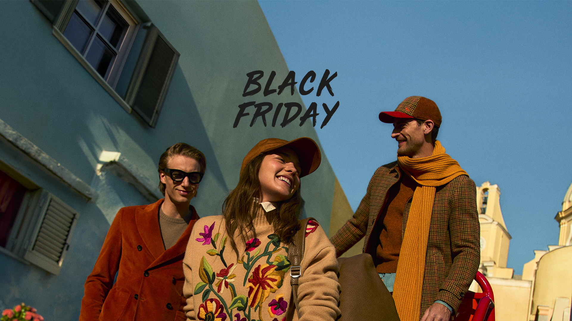 Pareja con abrigos de invierno frente a una gran flor azul.