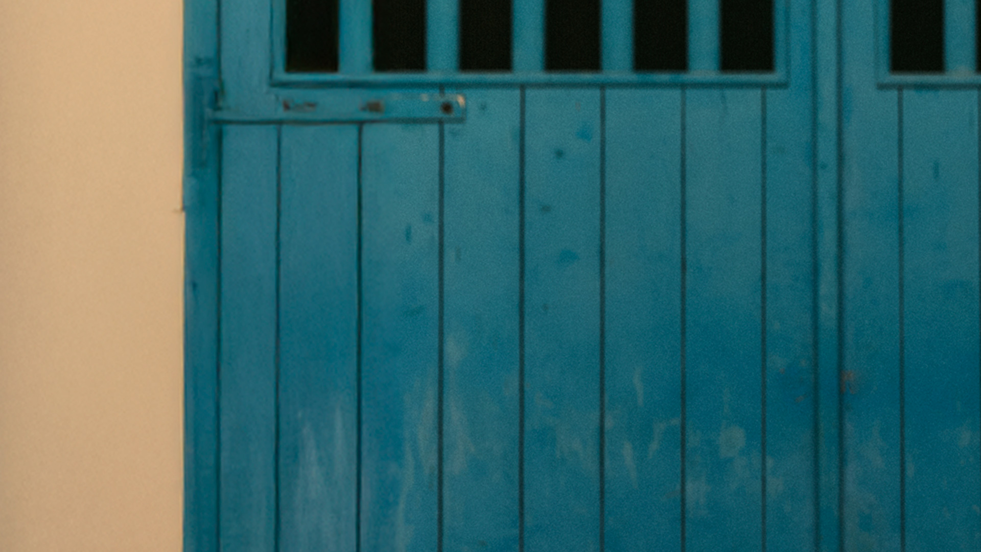 White plastic chair in front of a blue wall.