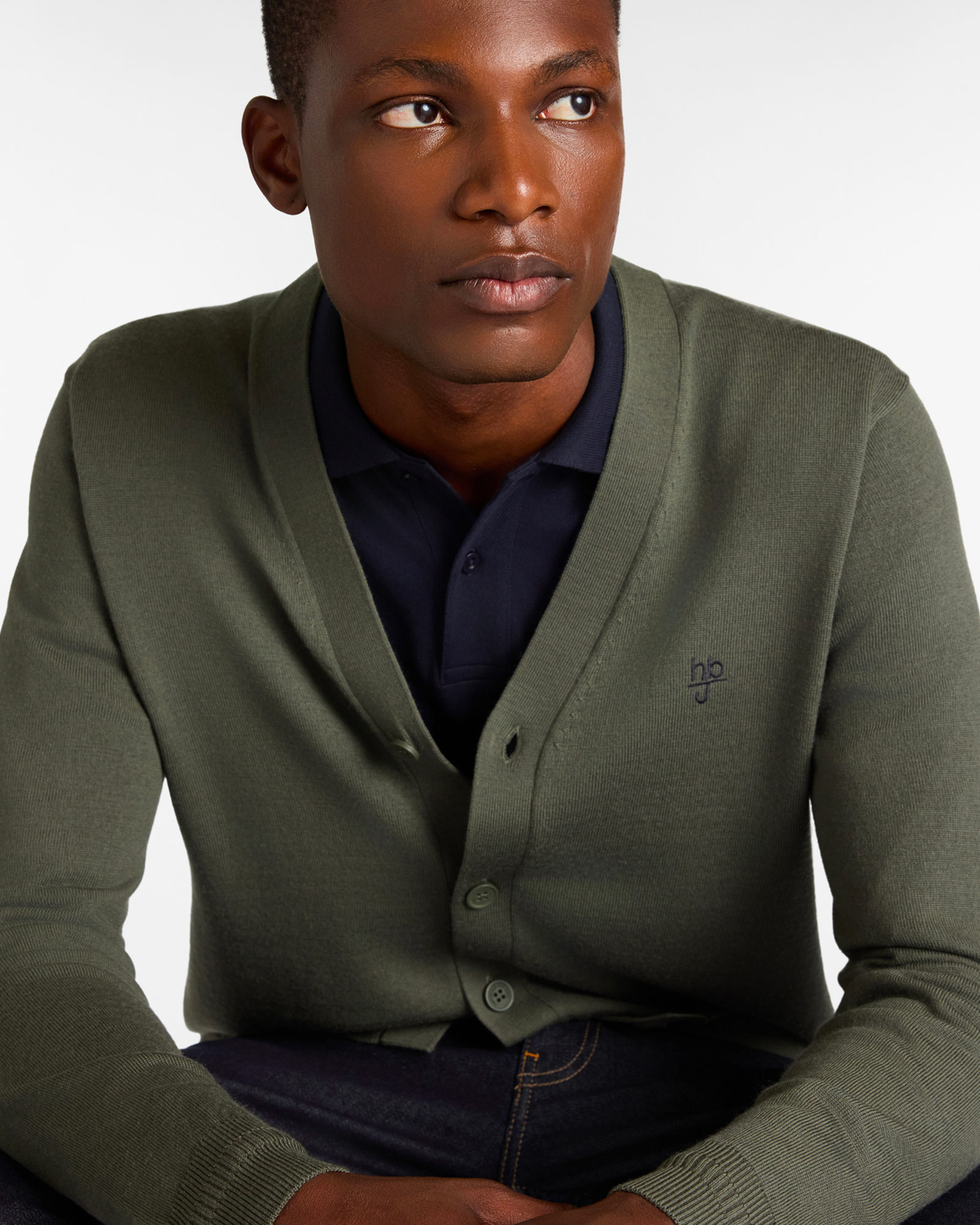 Uomo con cardigan verde e polo blu scuro