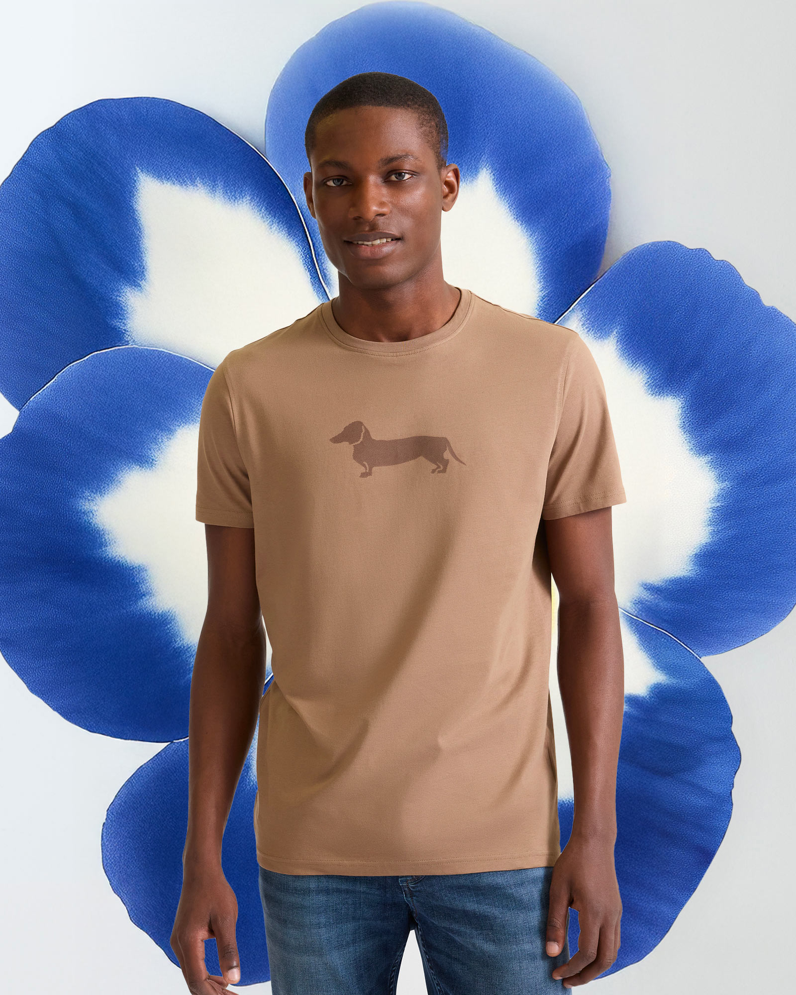 T-shirt bianca con grafica, sfondo floreale macro.