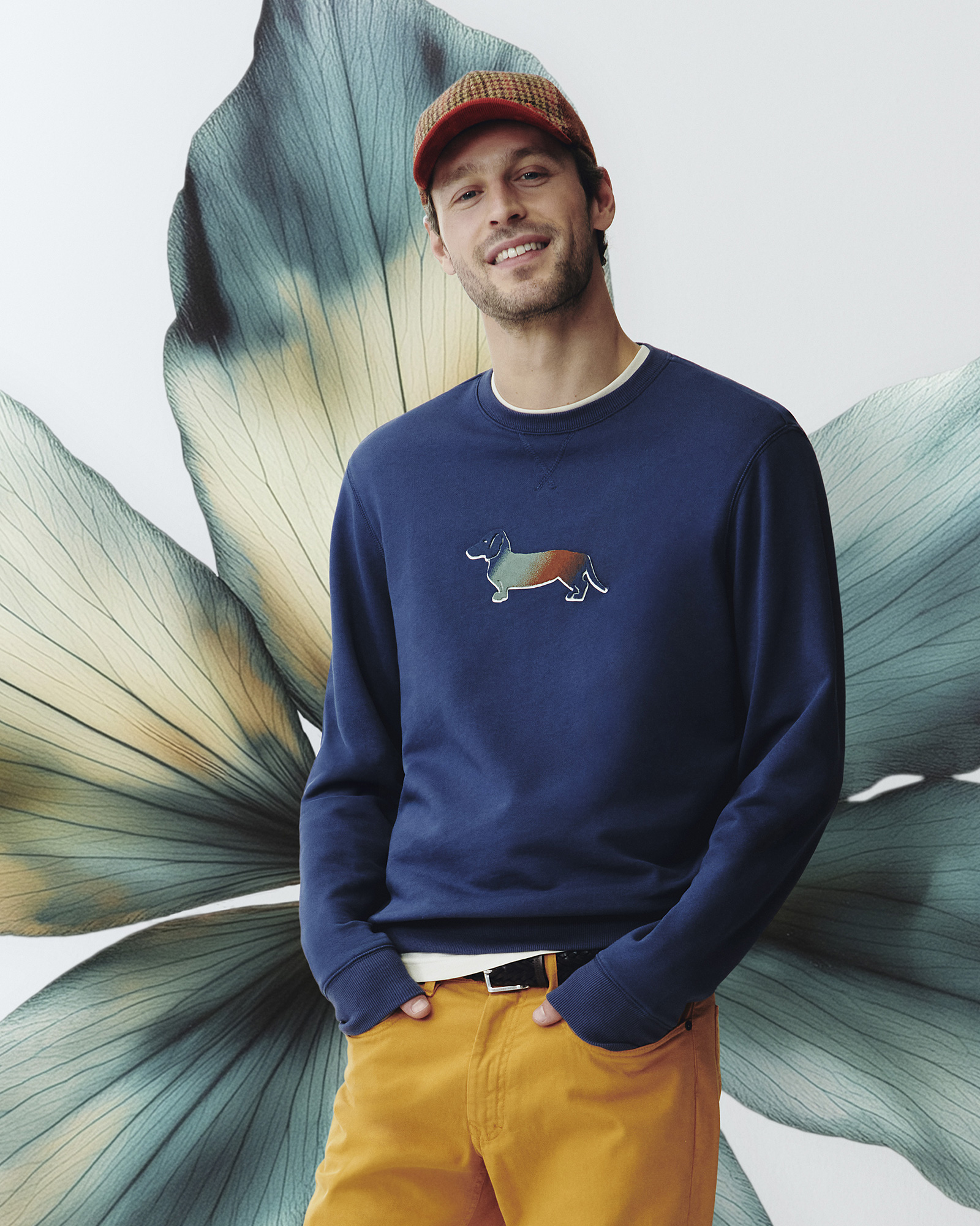 Man in navy sweatshirt with multicolor dog logo