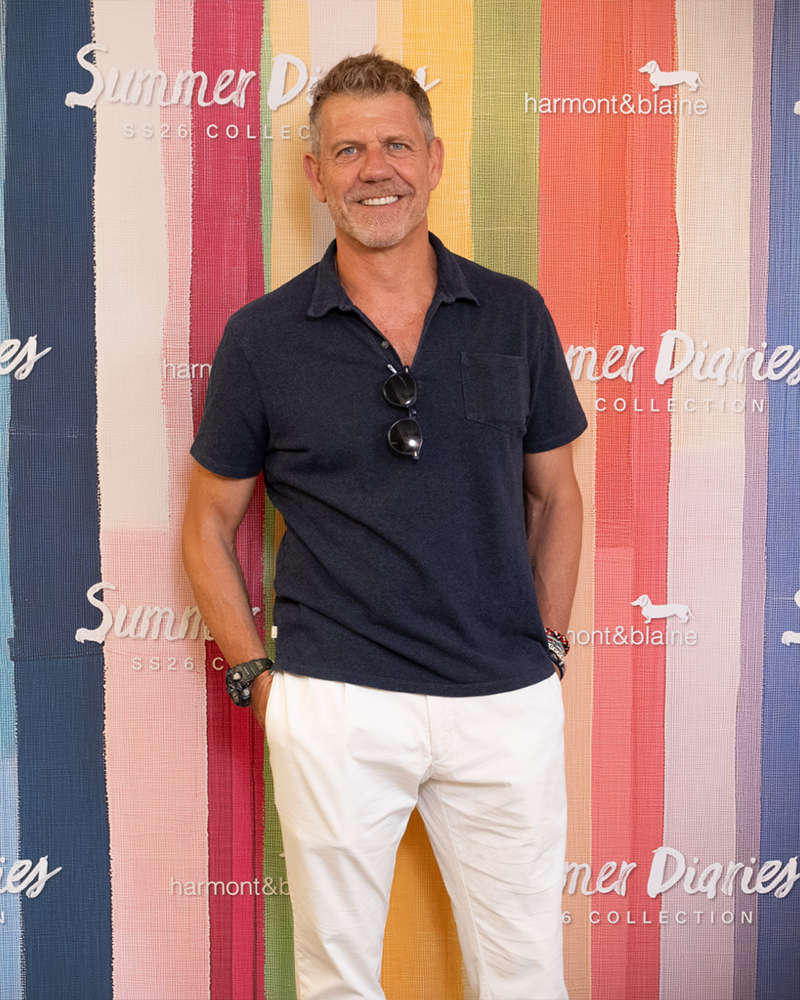 Uomo posa davanti al backdrop Summer Diaries.