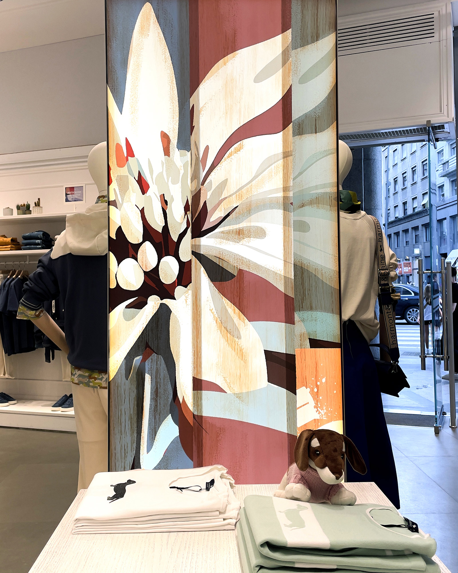 Escaparate Harmont & Blaine FW25 con gran flor estilizada y conjuntos denim y casual.
