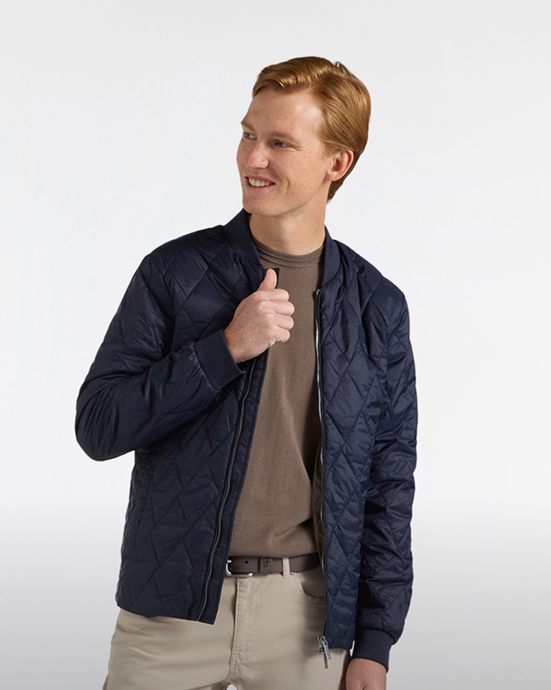 Uomo con piumino a quadretti con pantaloni beige