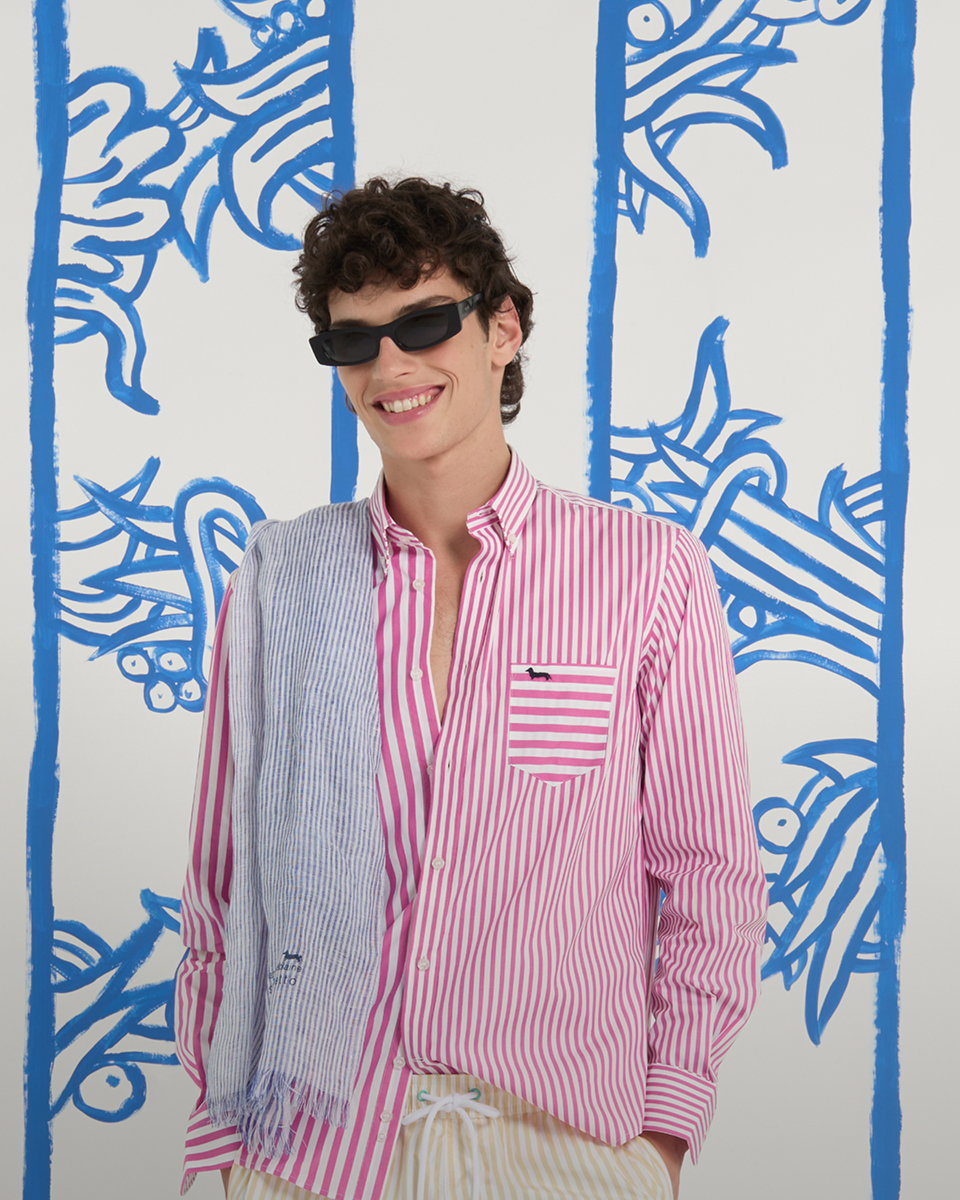 Donna con giacca a vento beige e camicia a righe con cappellino rosa