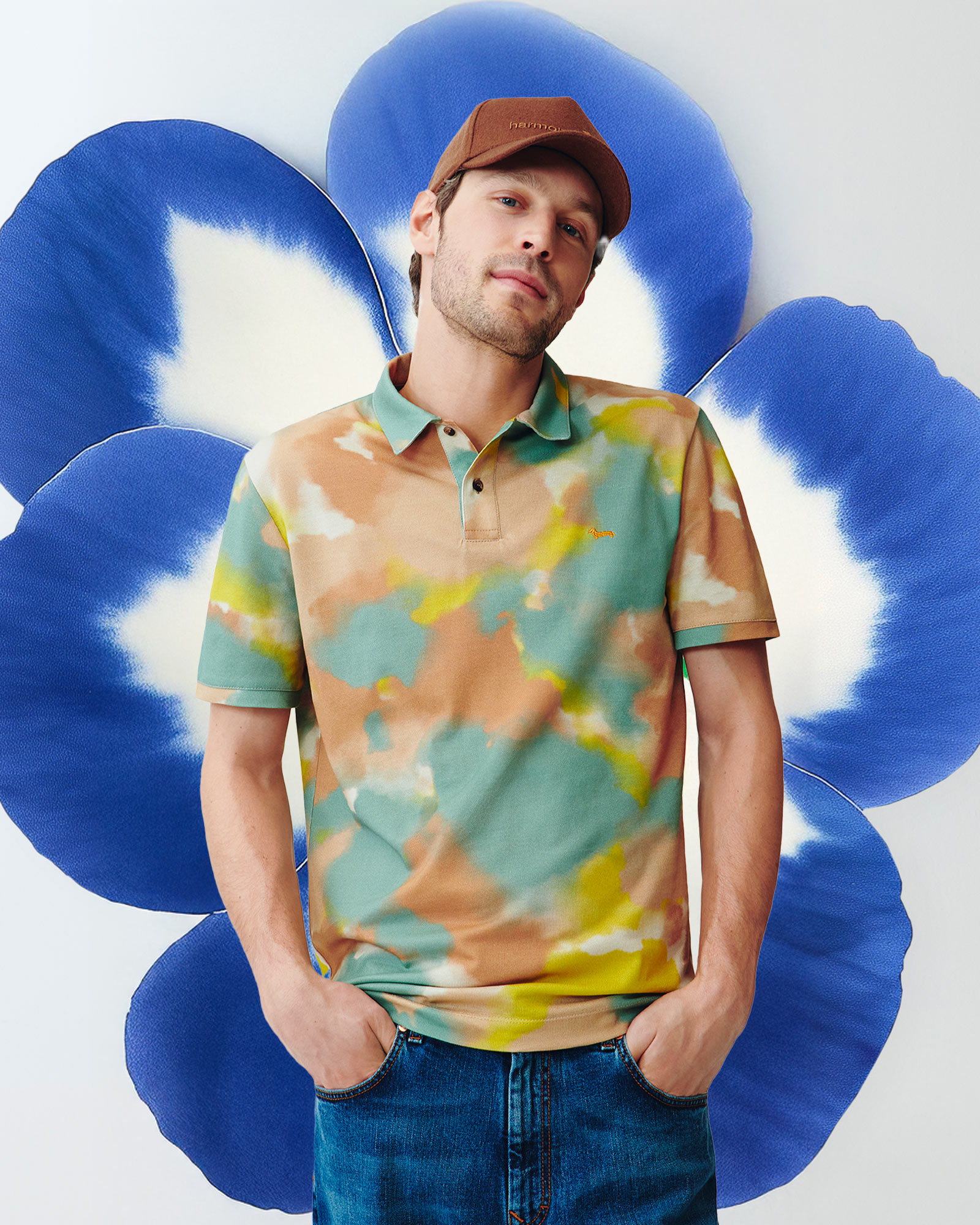 Camouflage print polo, stylized blue flower behind.