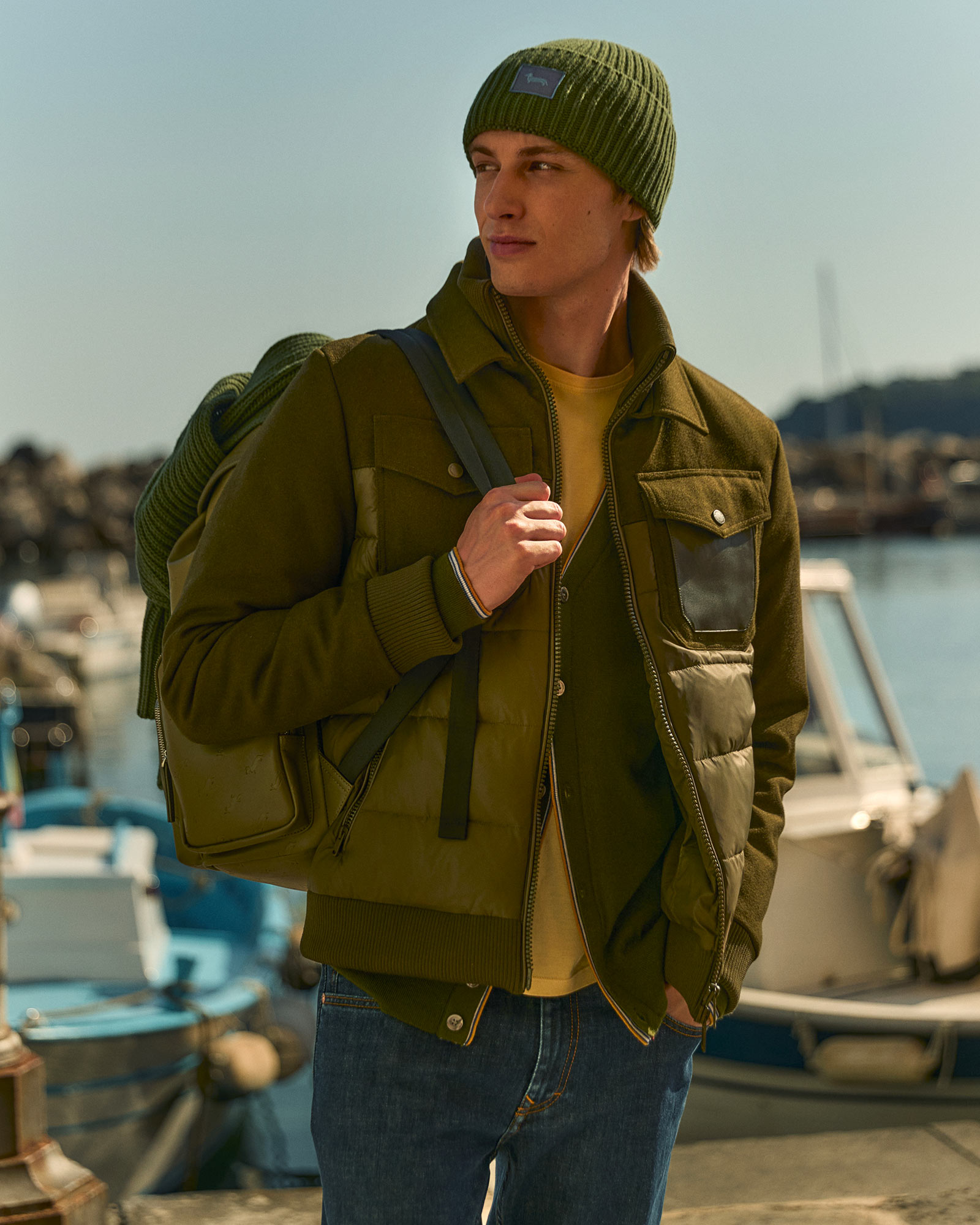 Model wearing a green jacket with matching beanie and backpack.