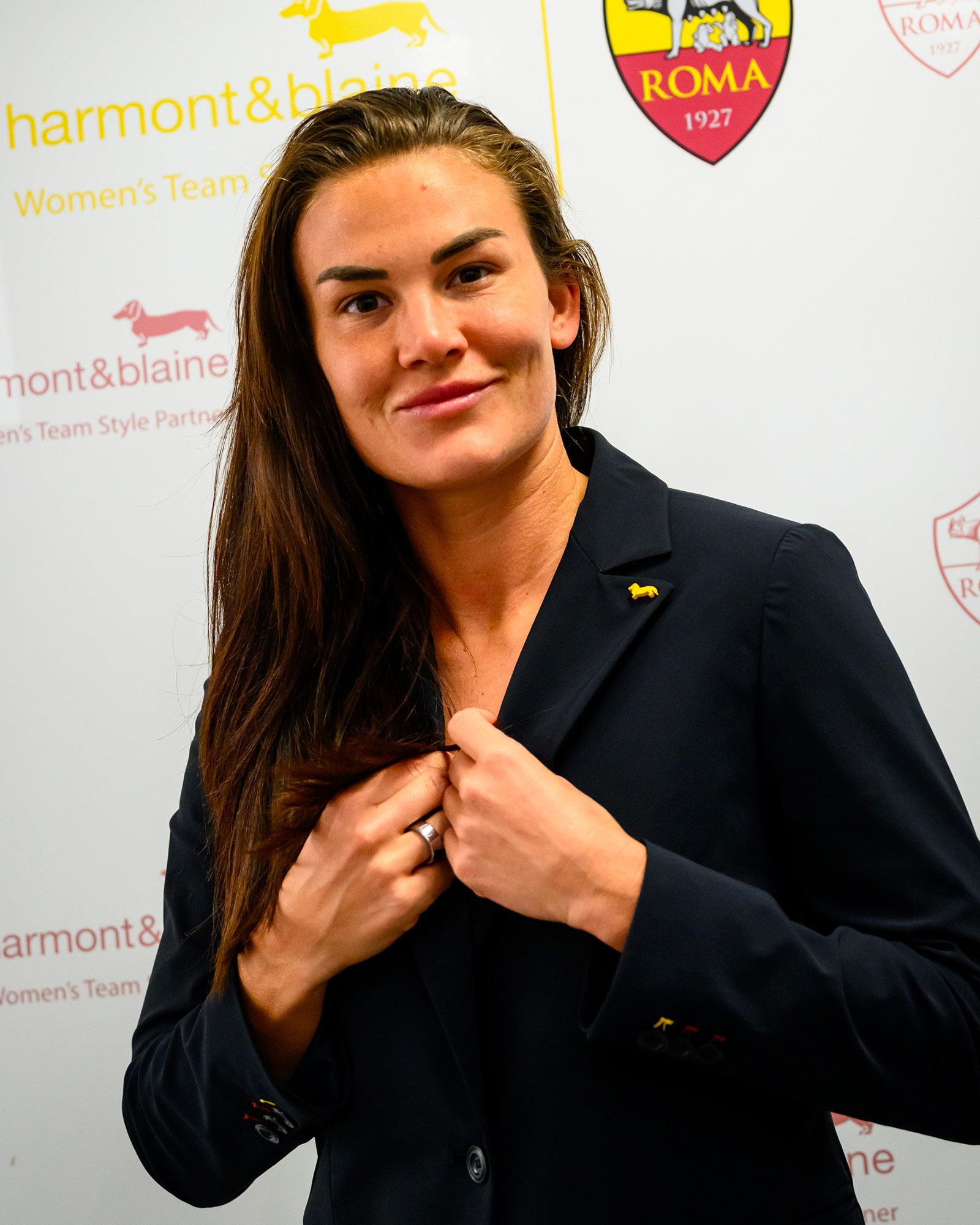 Donna con blazer blu navy che sistema il revers.