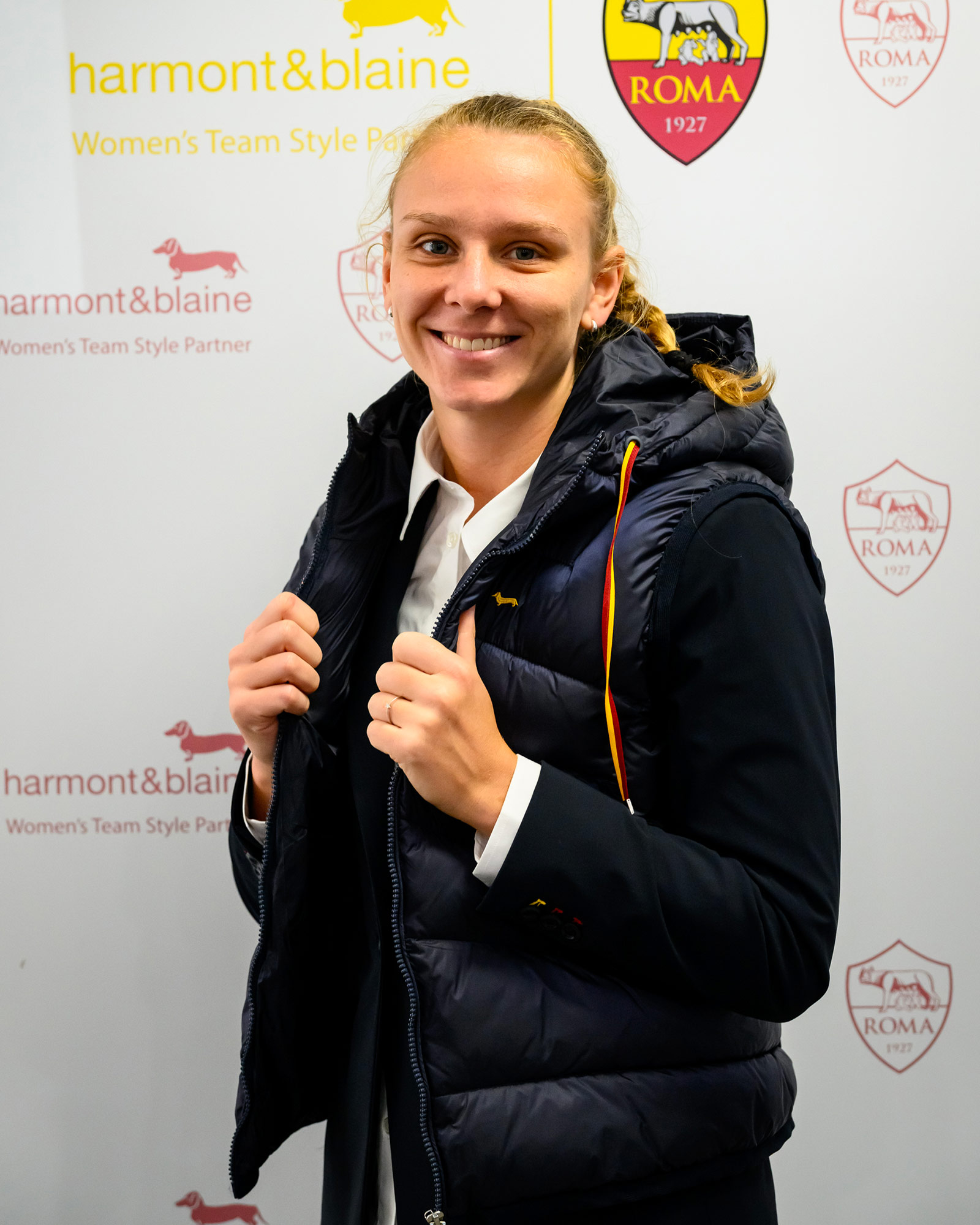 Donna con gilet imbottito blu navy sopra giacca elegante.