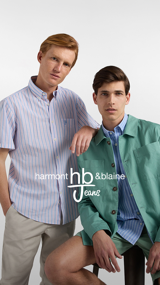Banner Saldi HB Jeans fino al -60%: due modelli uomo posano su sfondo bianco. Il ragazzo in piedi indossa una camicia a righe verticali bianche e azzurre a maniche corte e pantaloni chiari; il ragazzo seduto indossa una giacca leggera verde acqua sopra una camicia a righe e pantaloncini coordinati. Al centro compare il logo Harmont & Blaine Jeans