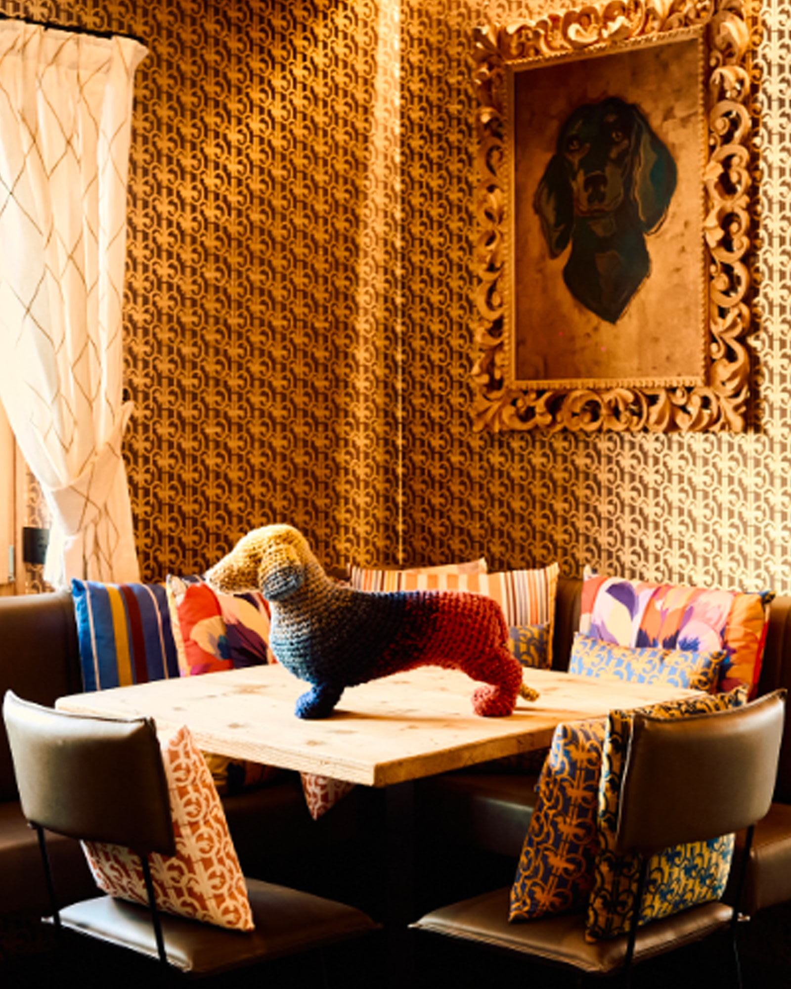 Vista esterna della boutique Harmont & Blaine con dettagli in legno, decorazioni blu navy e cuscini brandizzati &mdash; atmosfera accogliente dell&rsquo;evento &ldquo;Cortina a Colori&rdquo;.