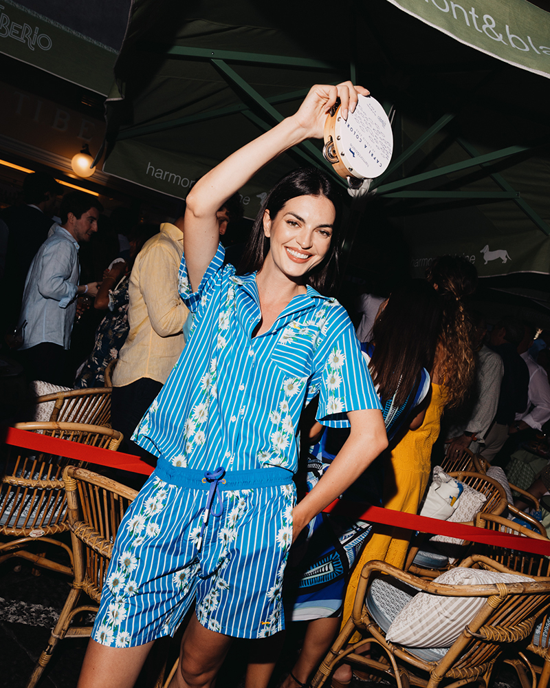 Donna in completo estivo blu balla con tamburello a Capri.
