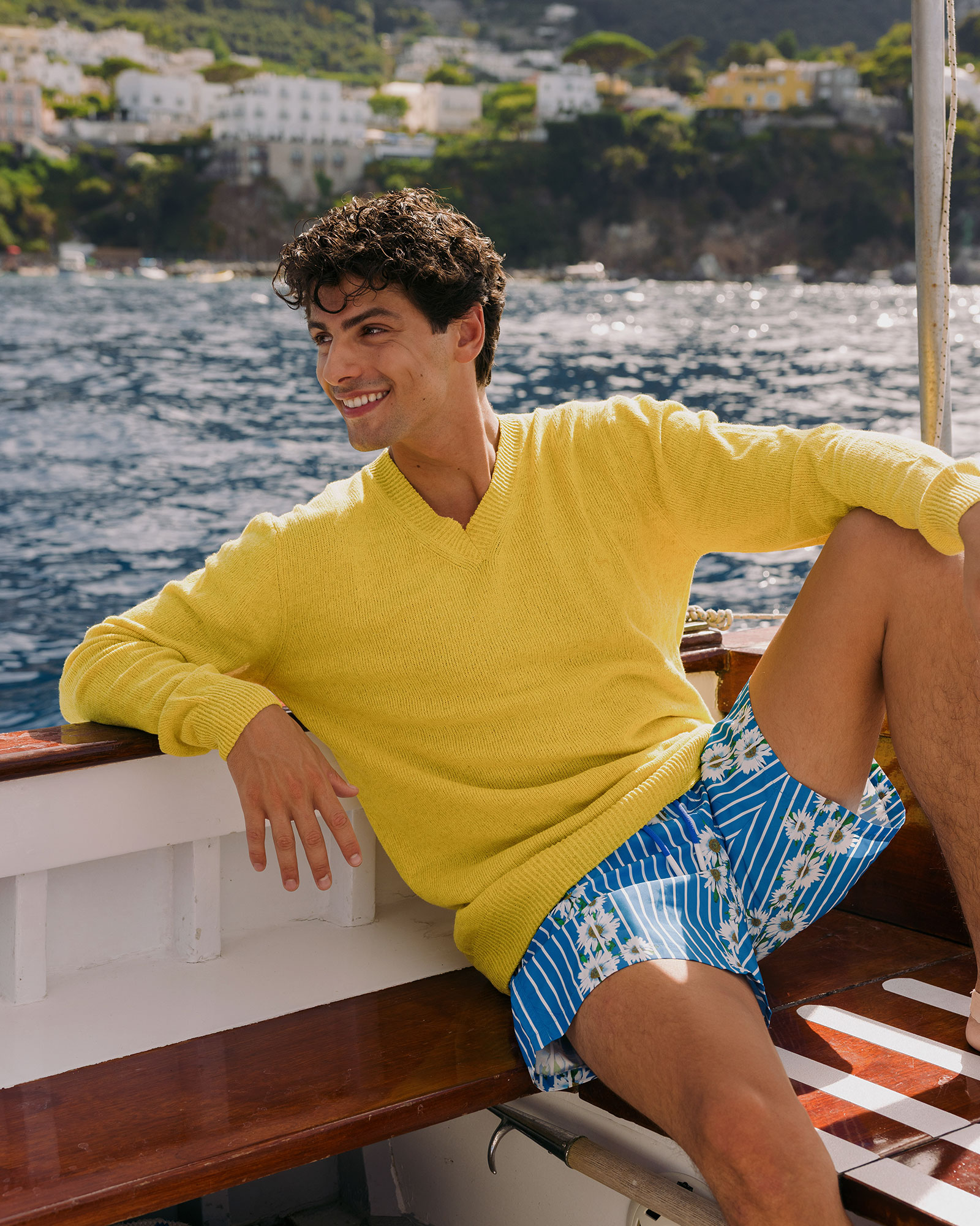 Uomo in maglia gialla a scollo a V abbinata a boxer mare blu stampati