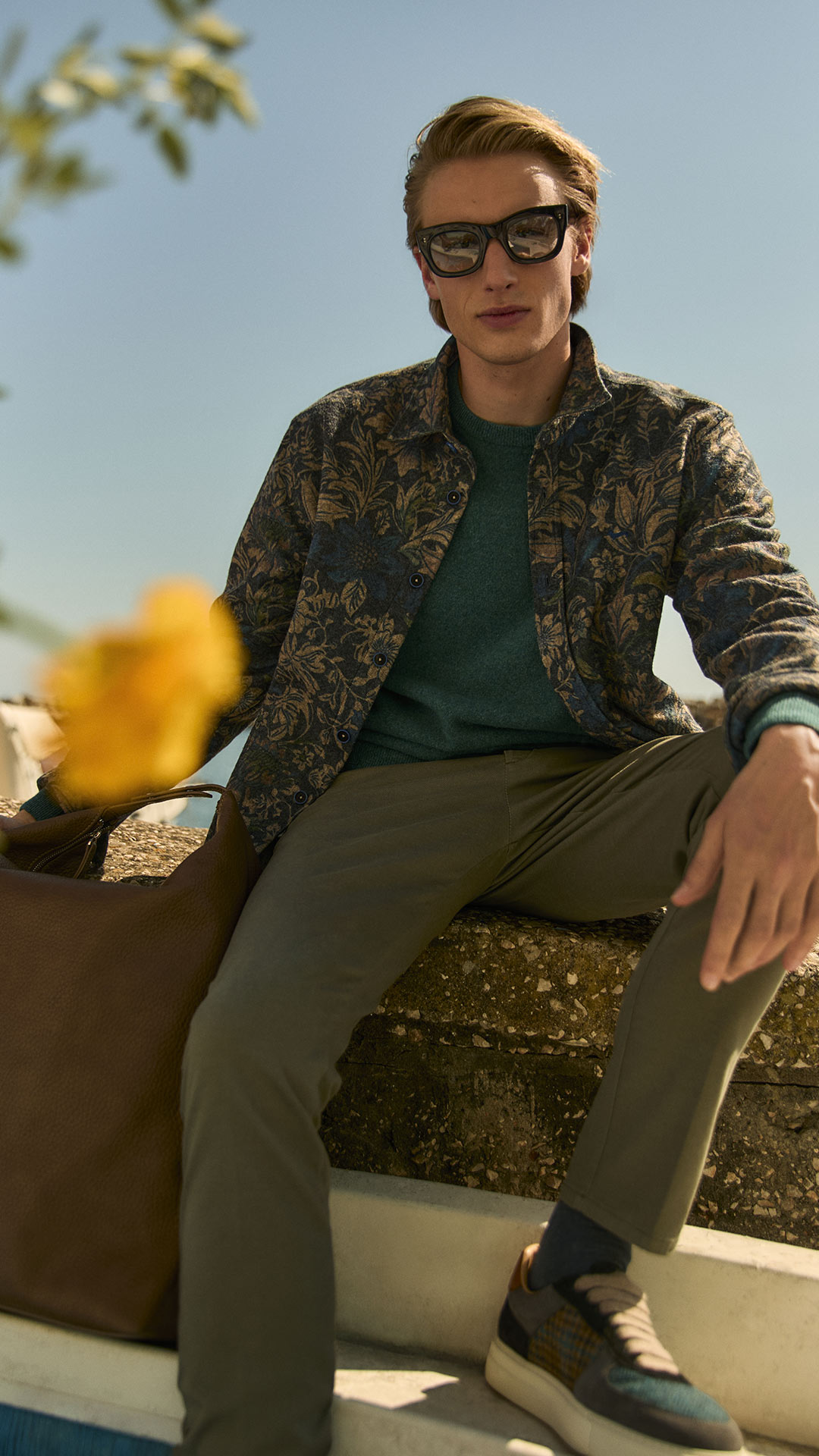 Close-up of man wearing patterned jacket and sunglasses