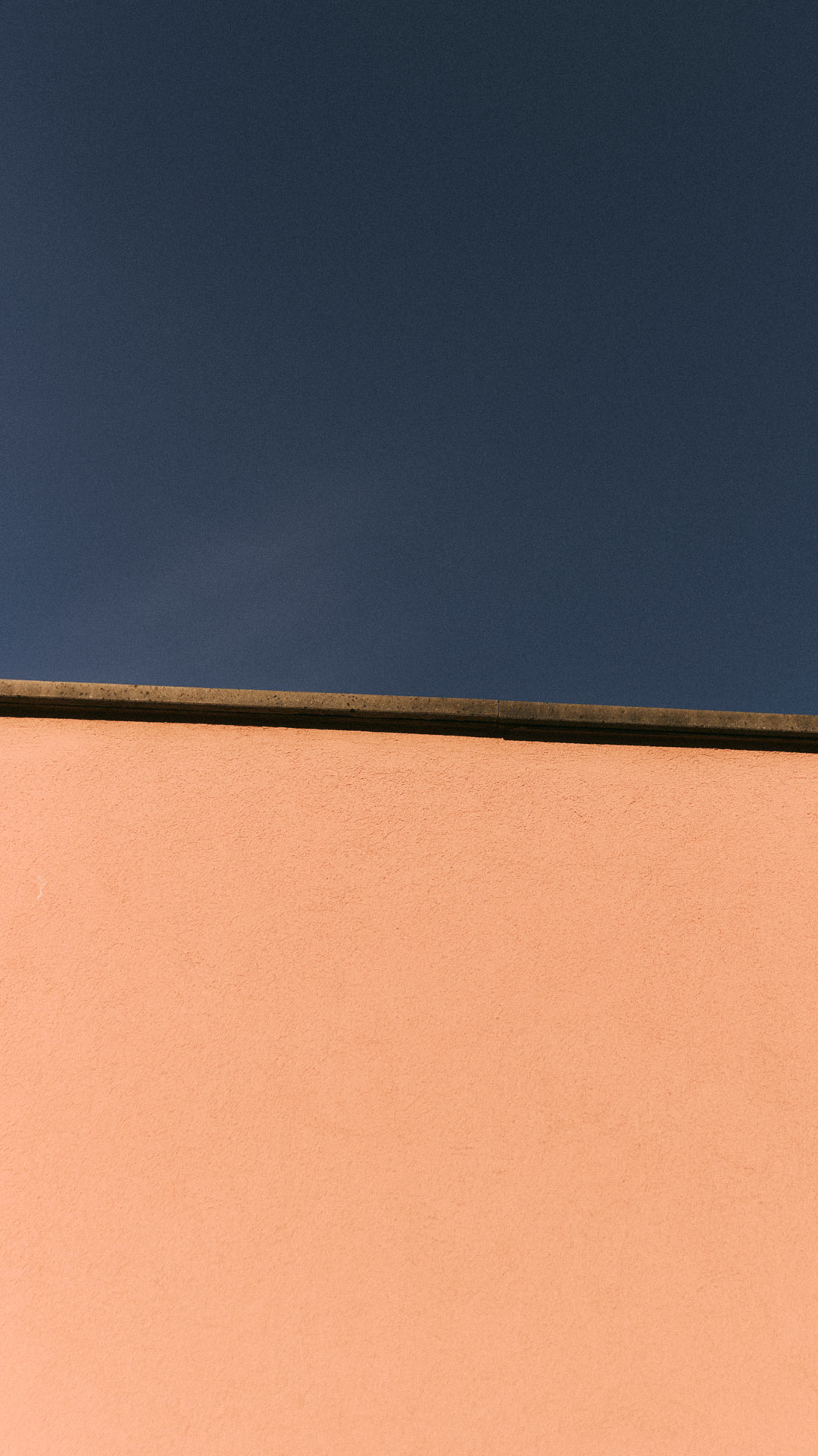 Parete rosa con cielo blu scuro sullo sfondo.