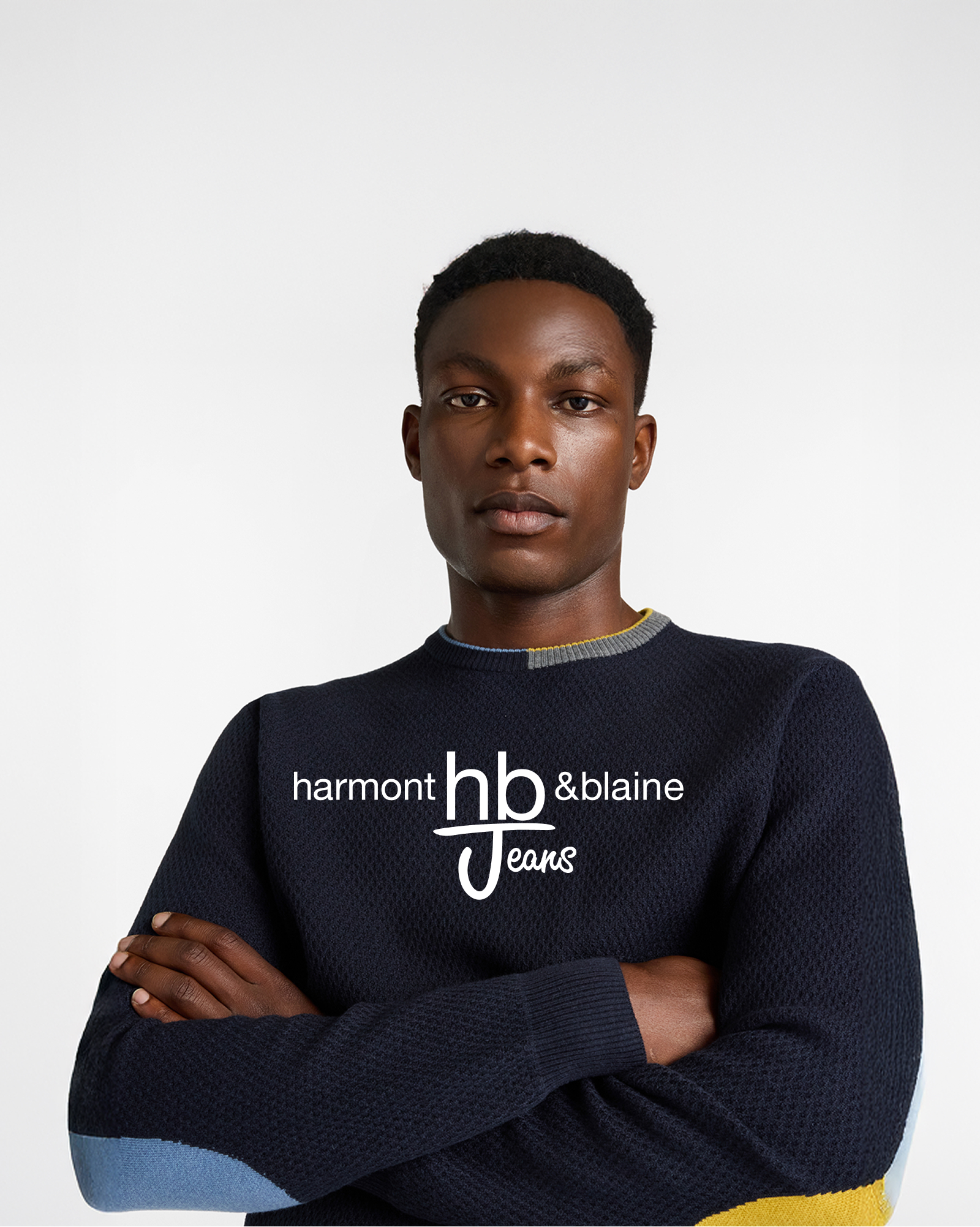 Felpa blu HBJ con logo ricamato e jeans scuri, immagine promozionale per i saldi HB Jeans.