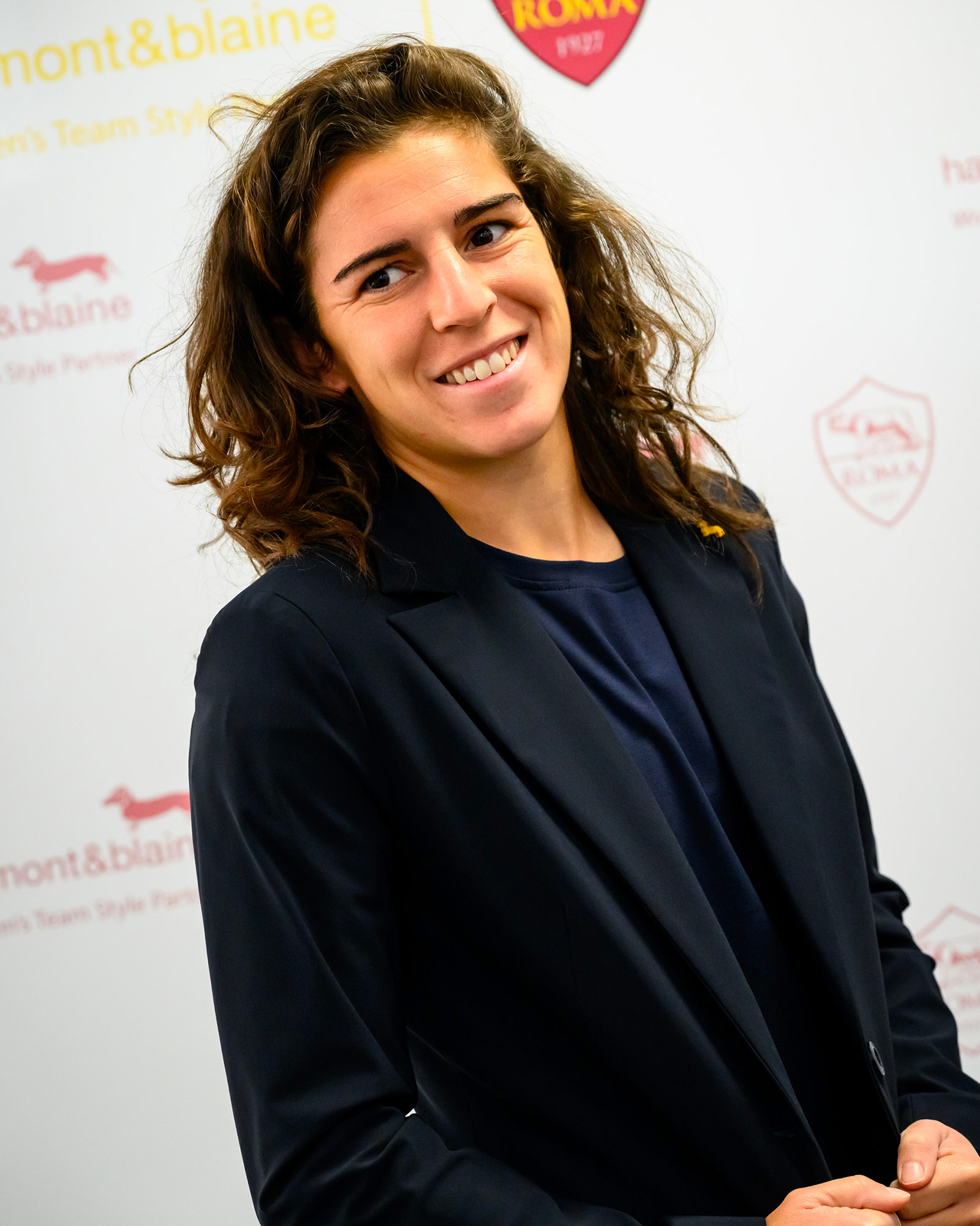 Donna con blazer blu navy e maglia blu.