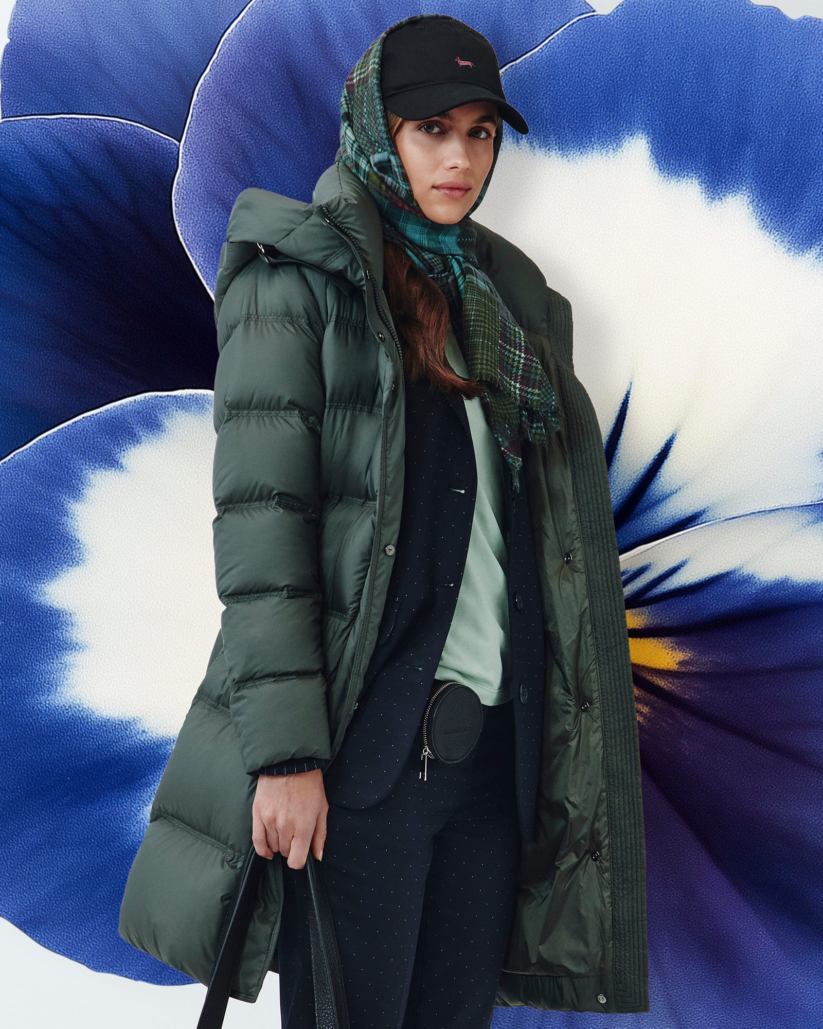 Donna con giacca in pelle nera, maglione a fantasia e marsupio beige