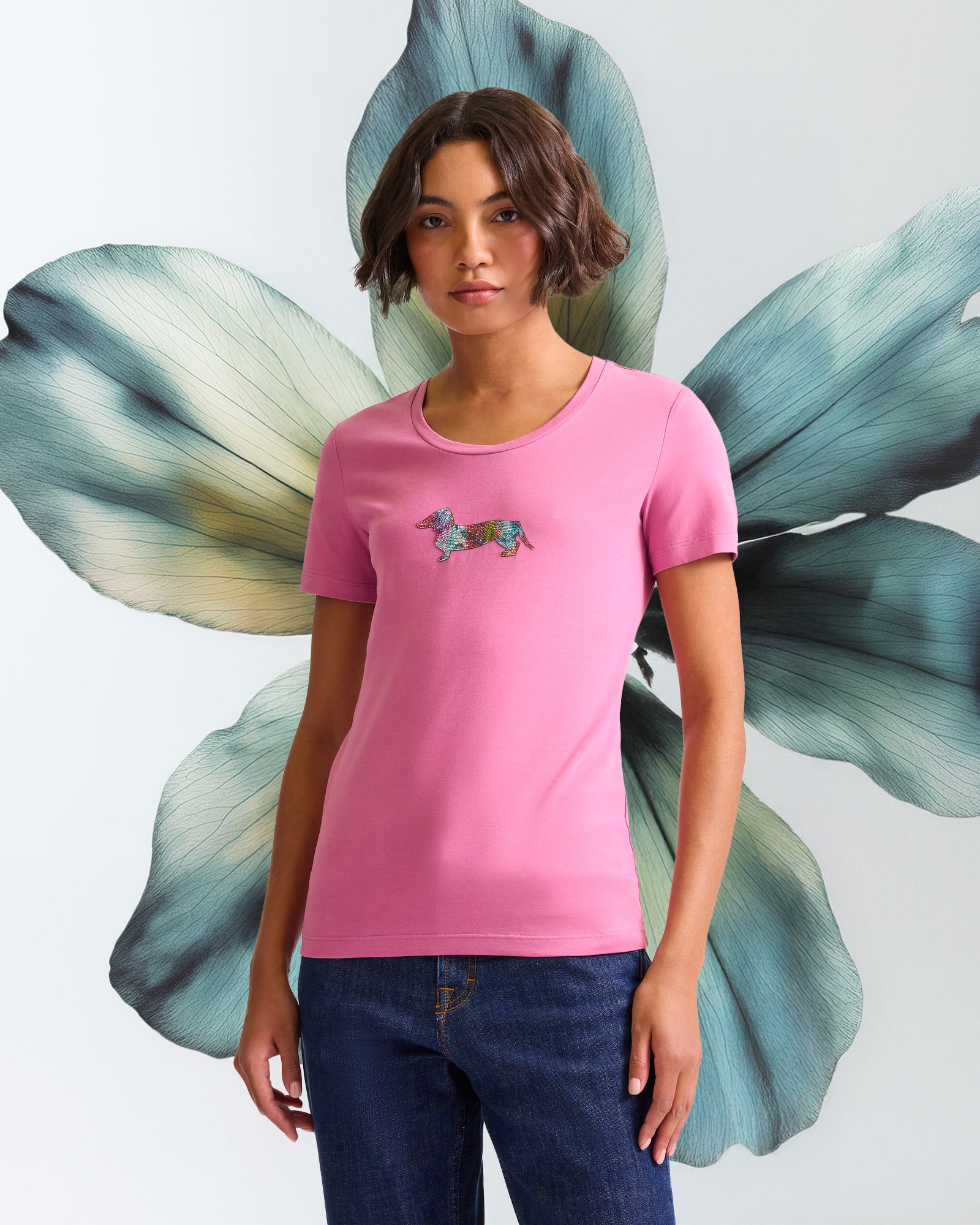 Graphic T-shirt with macro floral green and cream backdrop.