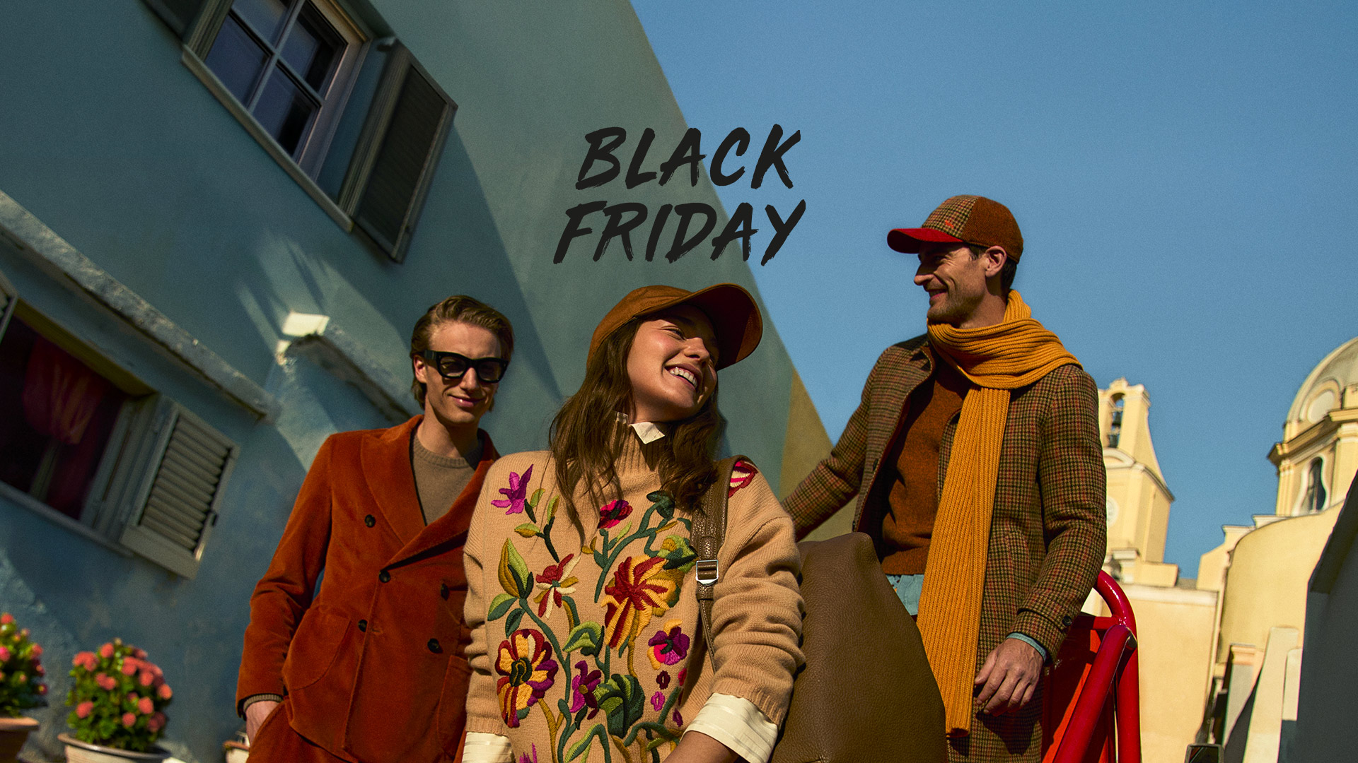 Pareja con abrigos de invierno frente a una gran flor azul.