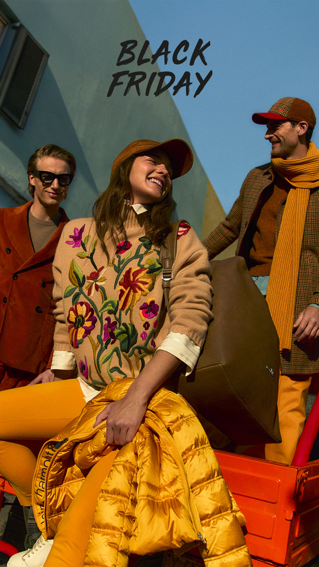 Coppia che indossa cappotti invernali davanti a un grande fiore blu.