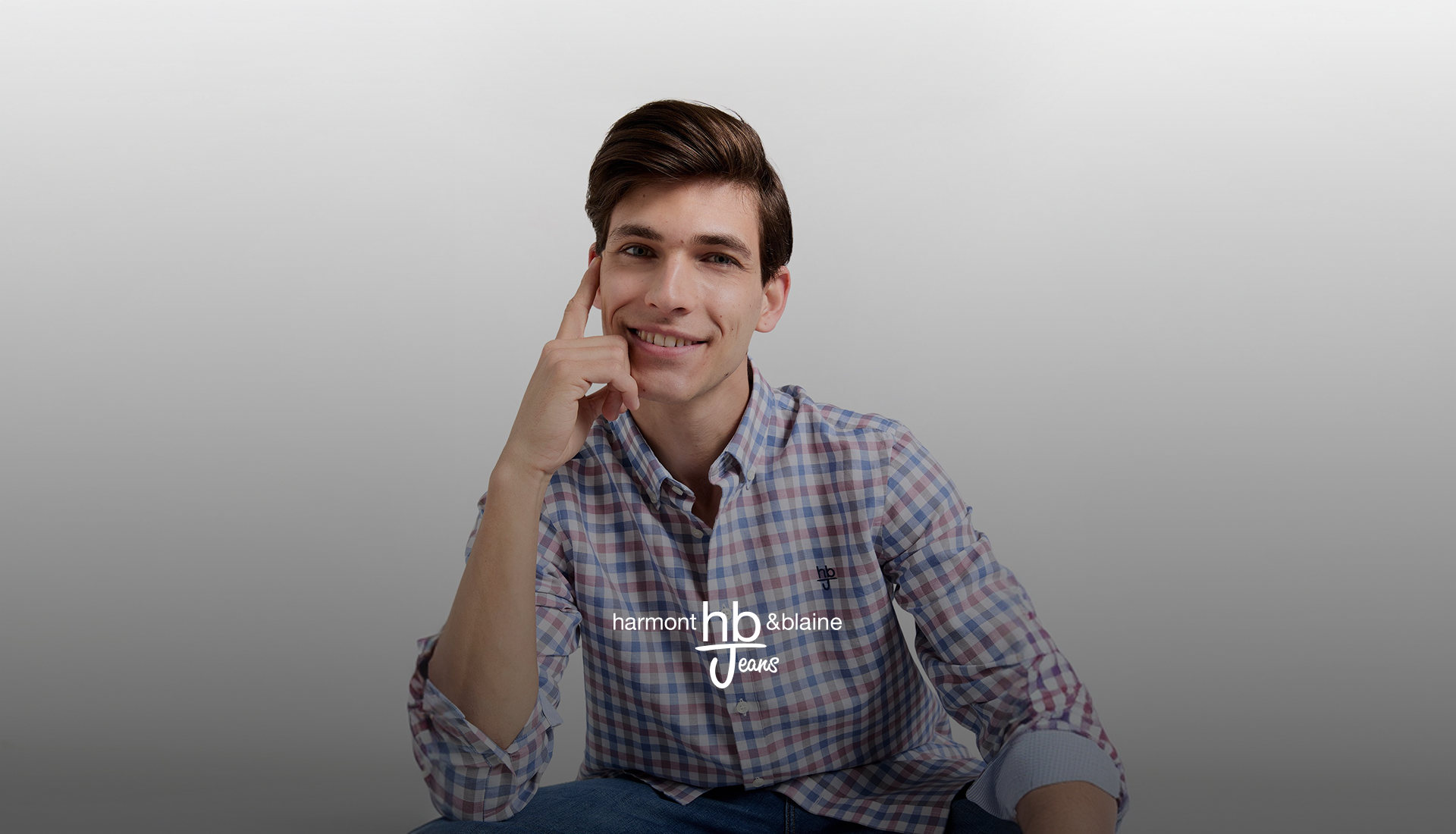 Felpa blu HBJ con logo ricamato e jeans scuri, immagine promozionale per i saldi HB Jeans.