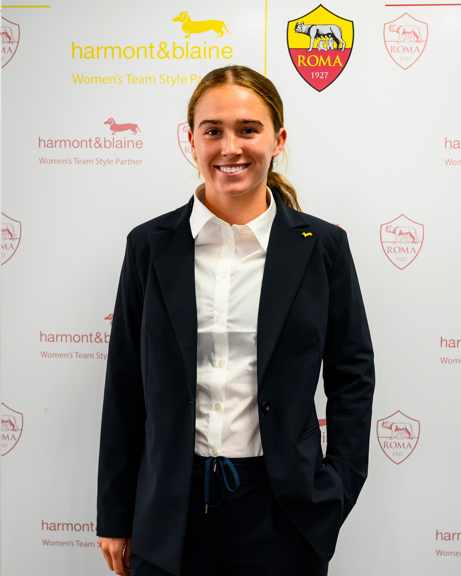 Donna con blazer blu navy e camicia bianca.