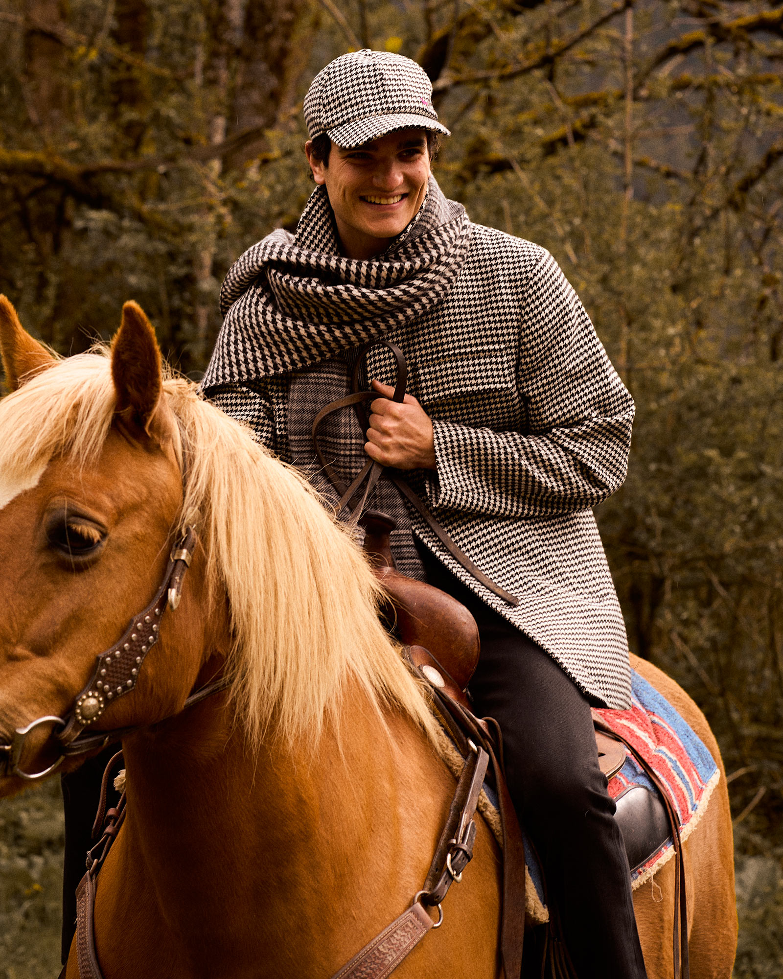 Houndstooth coat, outdoor scene with vegetation.