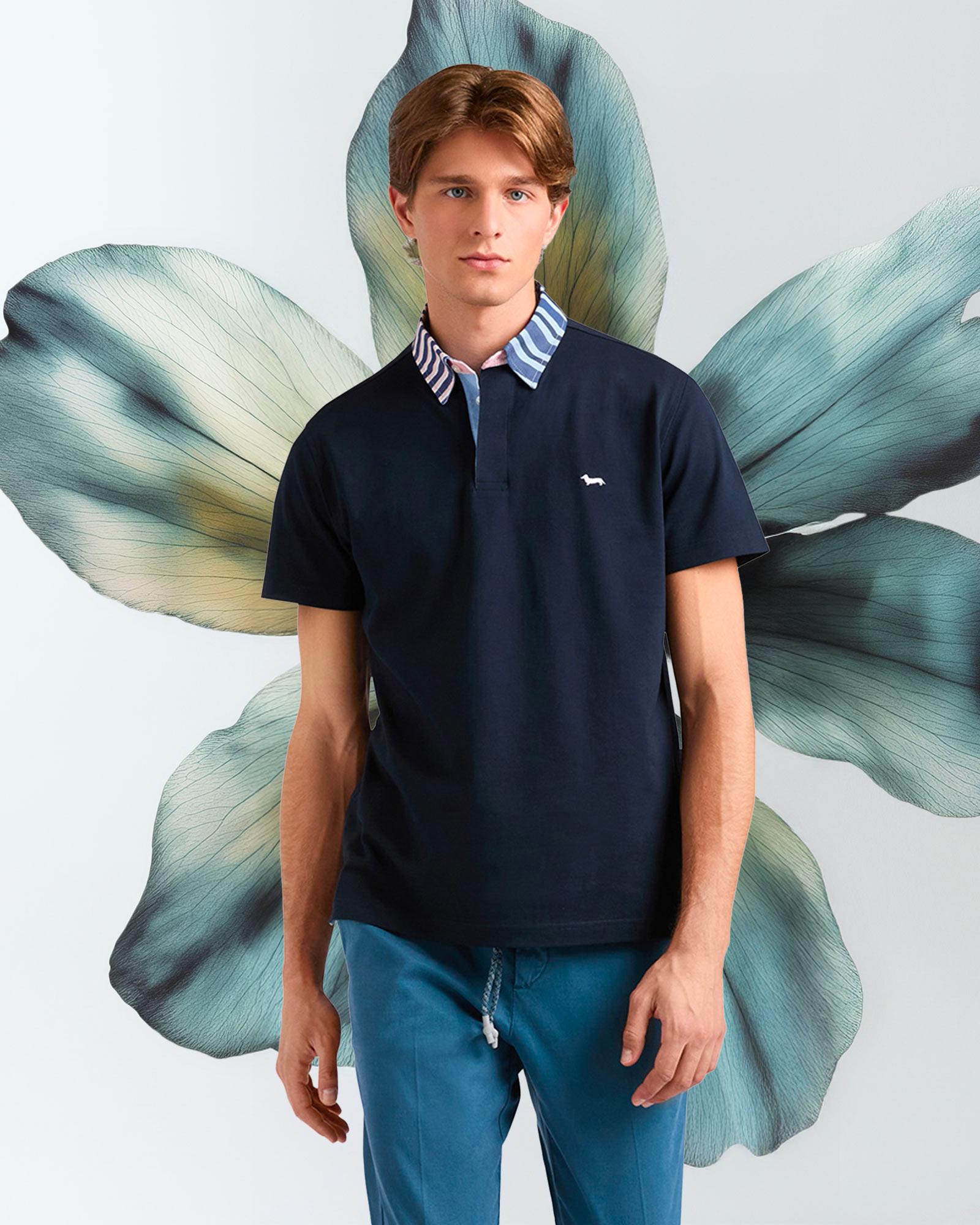 Polo con stampa camouflage, fiore blu stilizzato dietro.