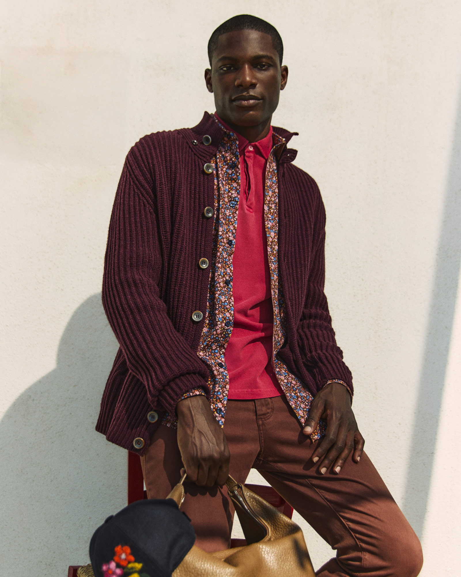 Uomo con cardigan bordeaux con dettagli floreali e polo rosa