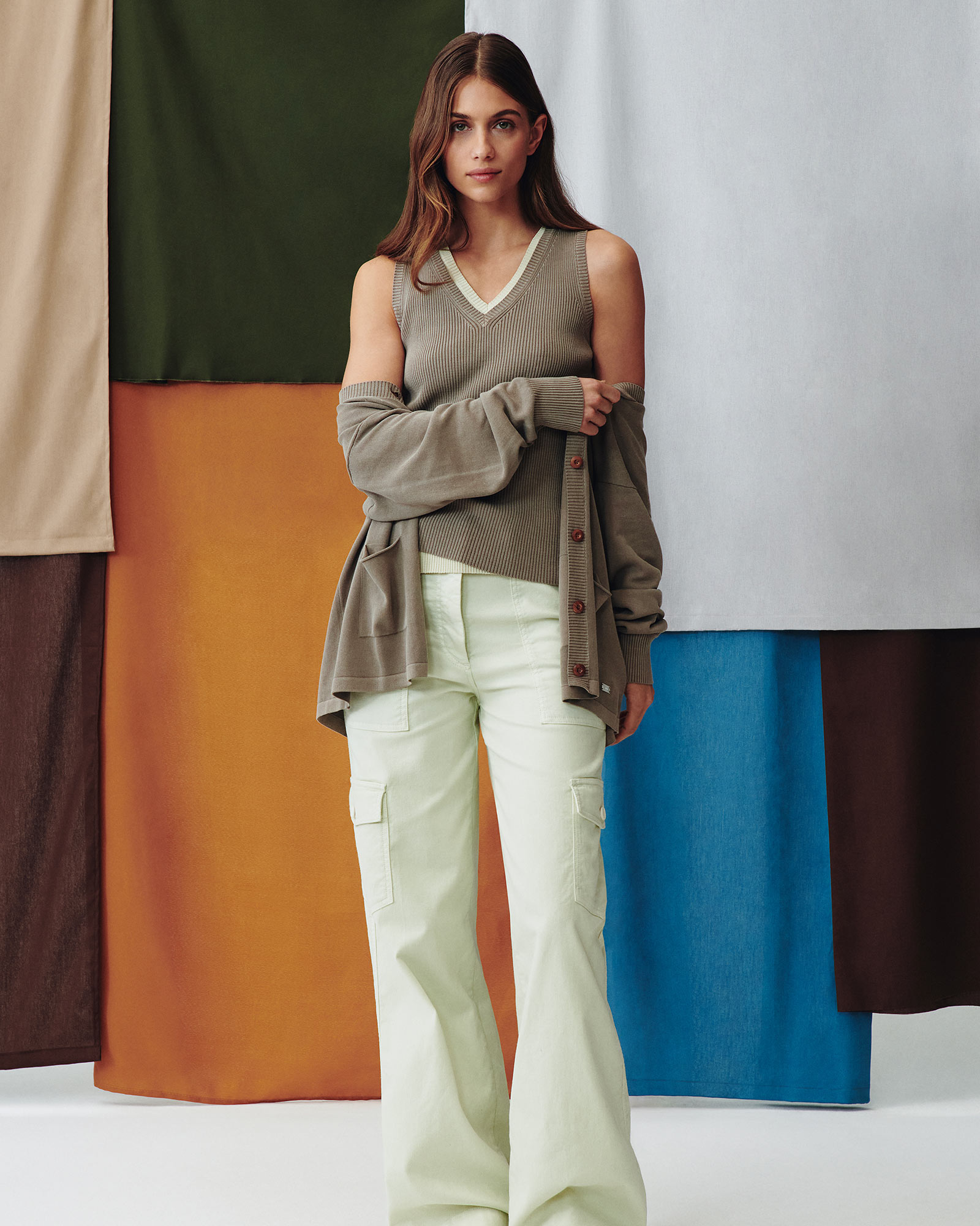 Woman wearing sleeveless top and light wide-leg trousers.