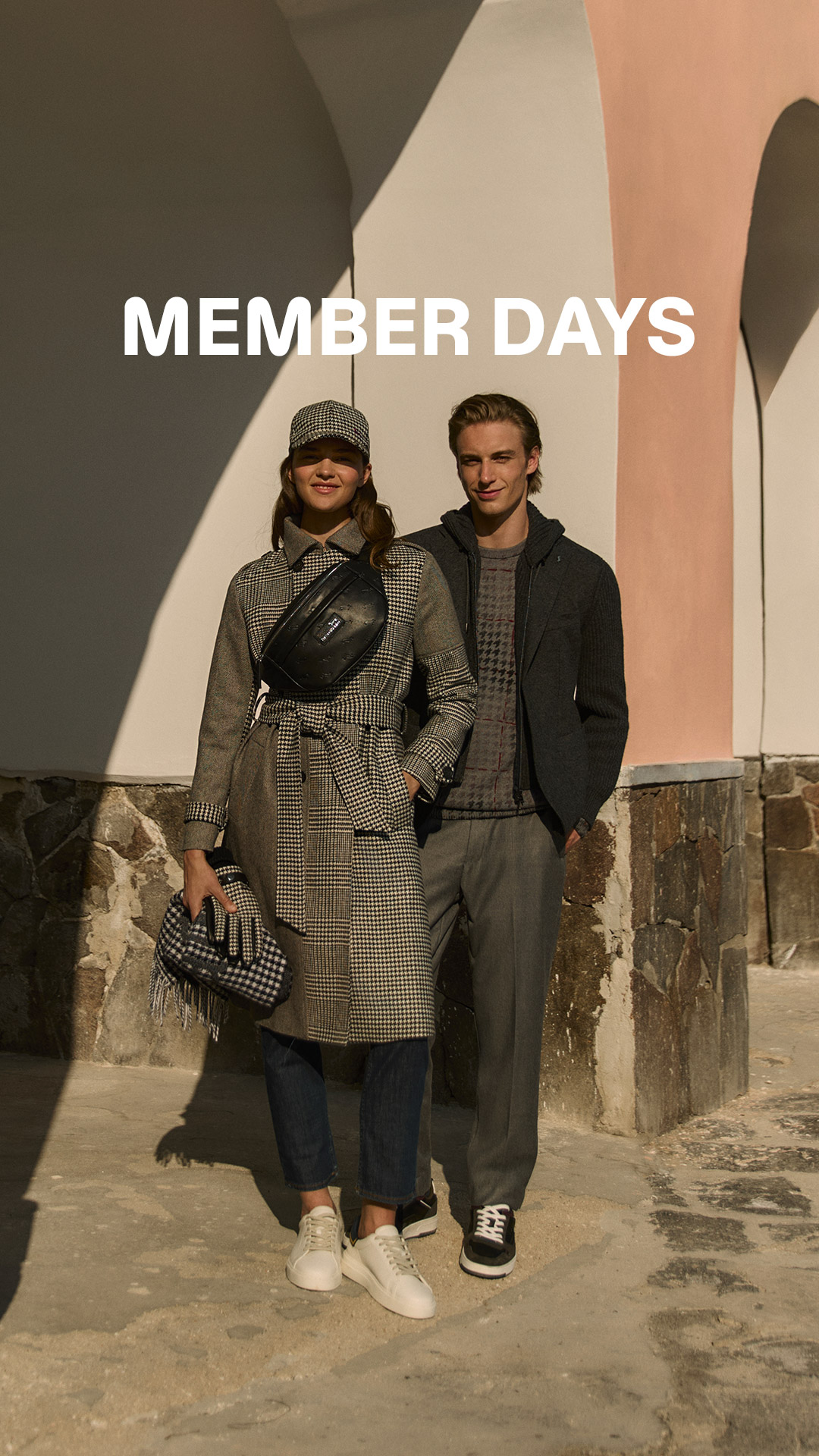 CoppDue persone in posa all’aperto davanti a un edificio con archi, indossano capi invernali Harmont & Blaine. Testo ‘MEMBER DAYS’ in alto, immagine che promuove l’anticipo dei saldi riservato ai clienti registrati.ia che indossa cappotti invernali davanti a un grande fiore blu.
