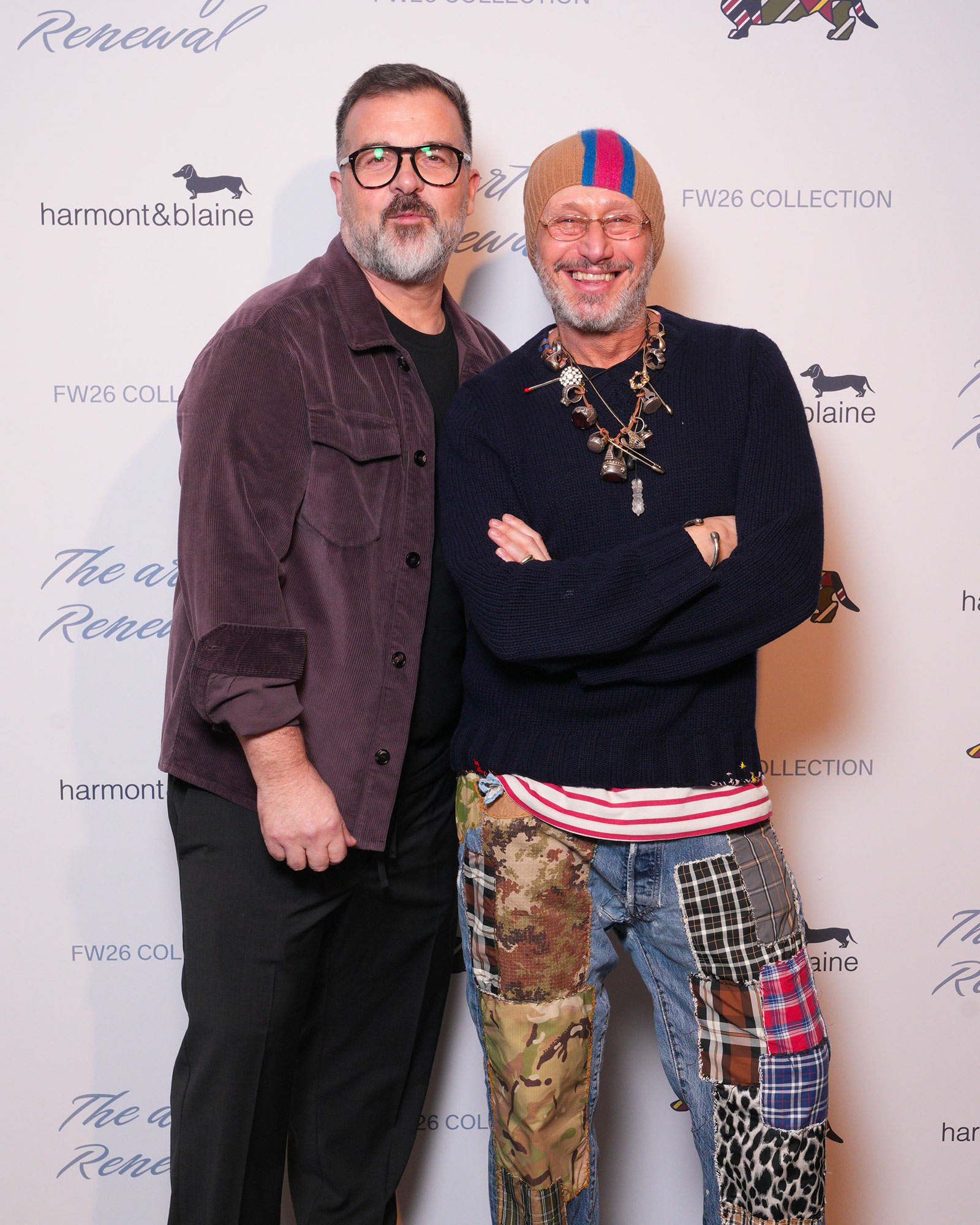 Due uomini in look casual, uno con giacca velluto viola, l'altro con maglia blu e pantaloni patchwork