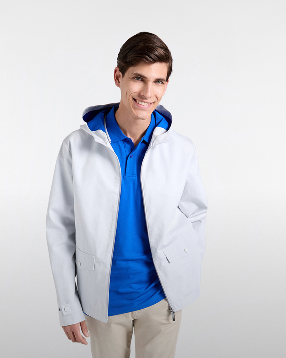 Uomo con polo rugby a righe verdi, blu e bianche