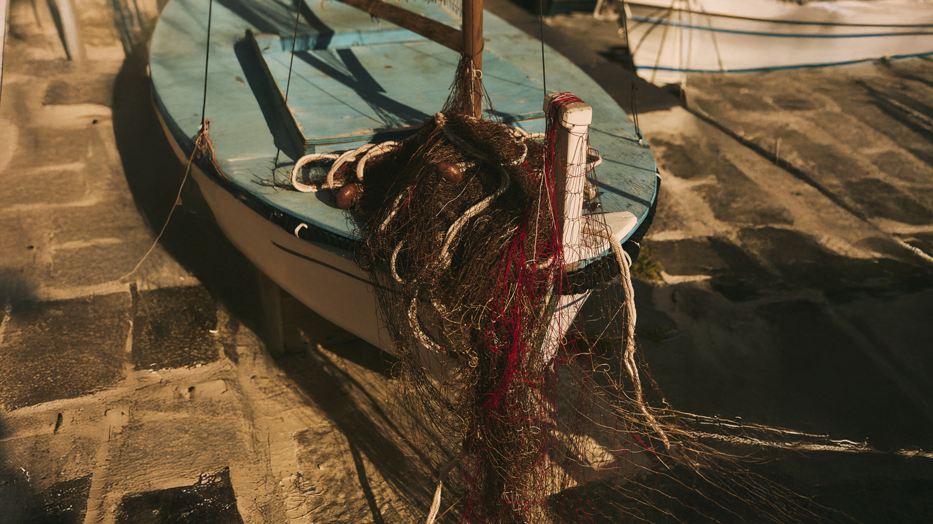 Fishing boat with tangled fishing net on deck.