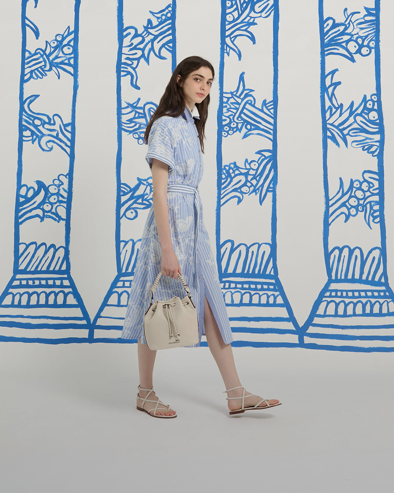 Cappotto lungo e sciarpa a quadri, sfondo illustrato.