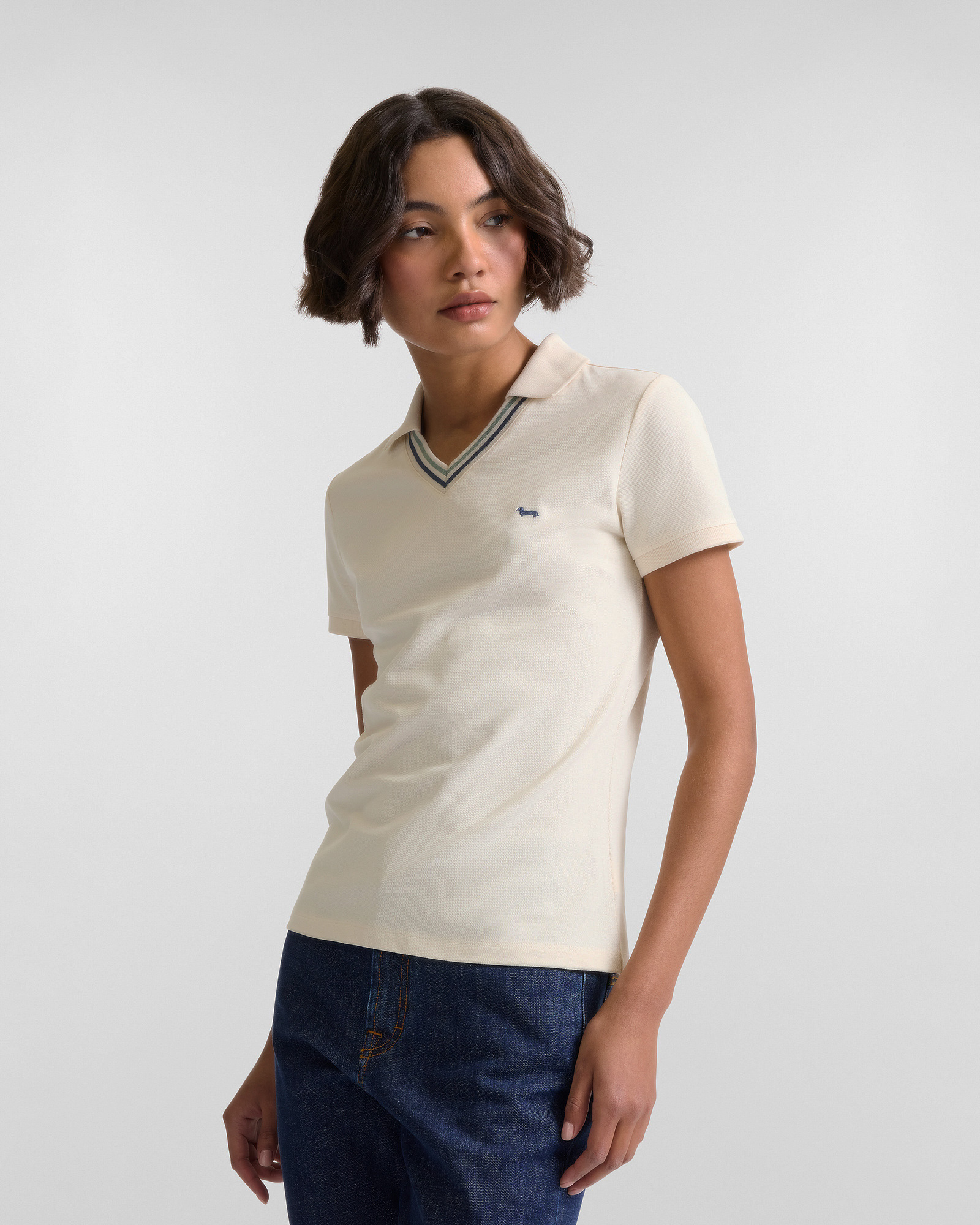 Donna con polo beige a maniche corte e jeans scuri