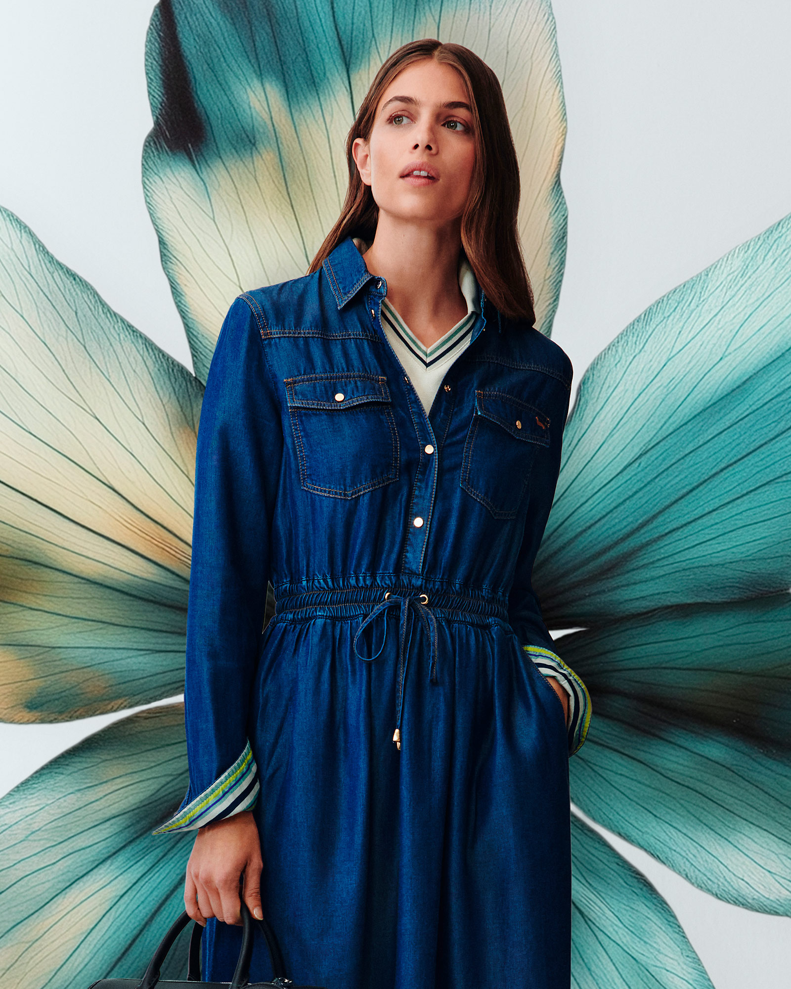 Woman wearing navy blue denim dress and pom-pom beanie